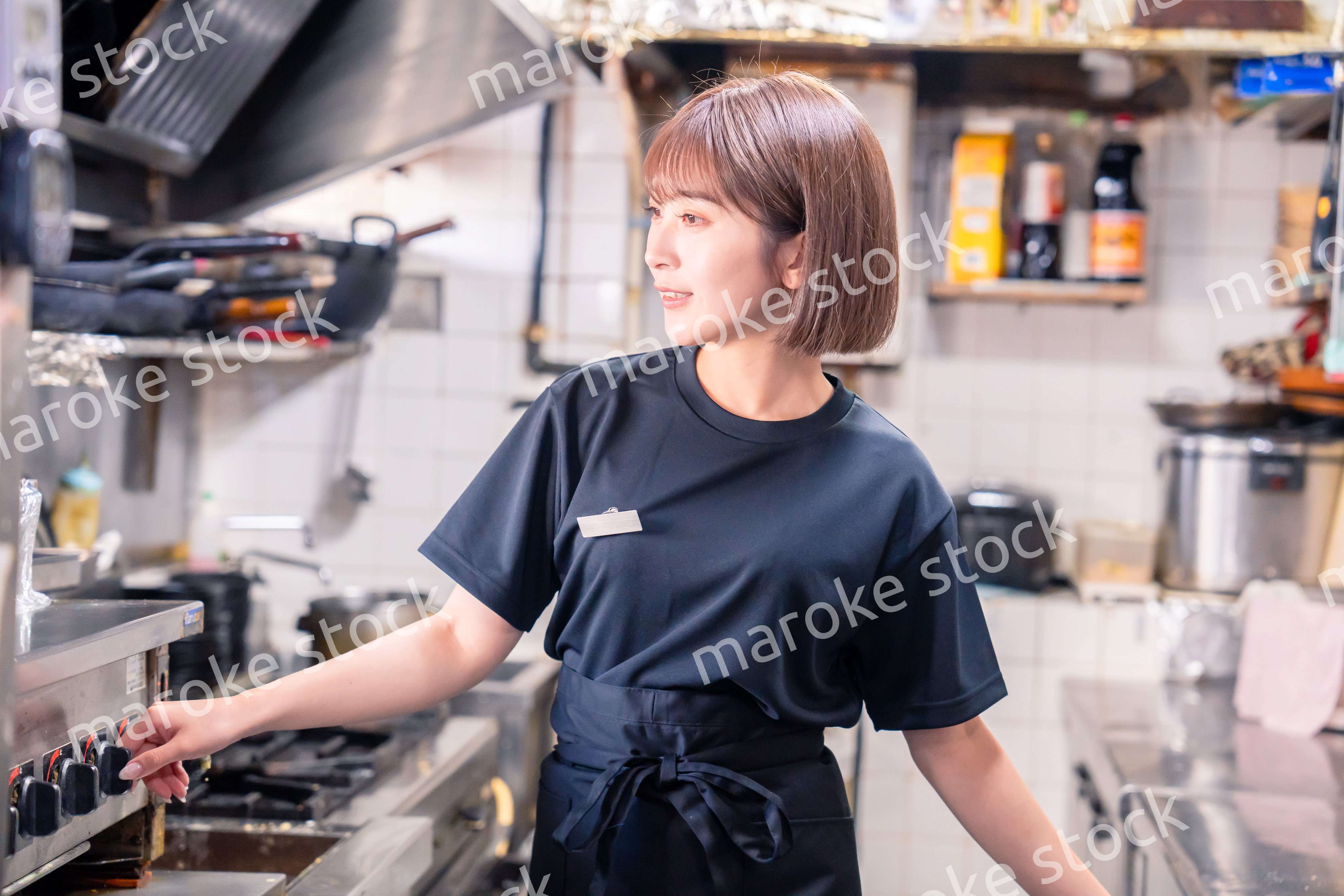 居酒屋の厨房で働くキッチンスタッフの女性