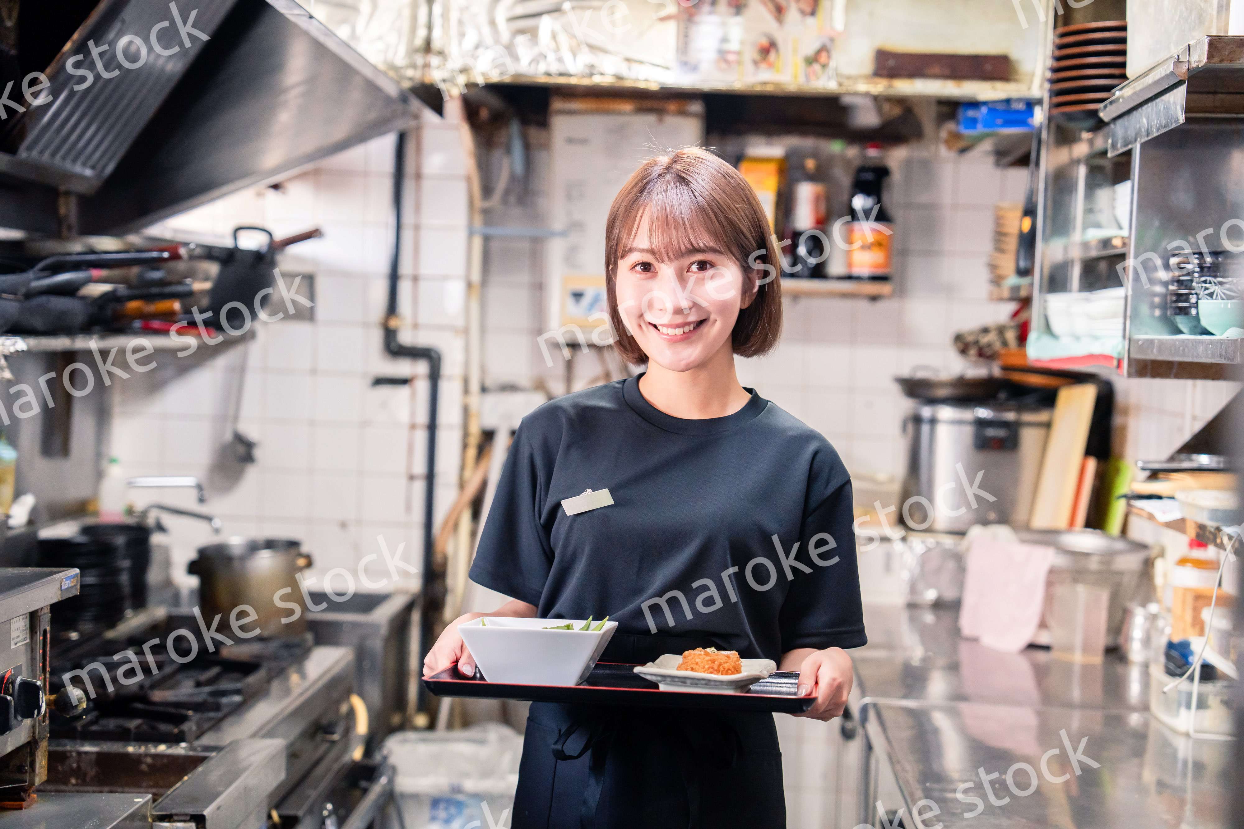 飲食店の厨房で働く若い女性のスタッフ