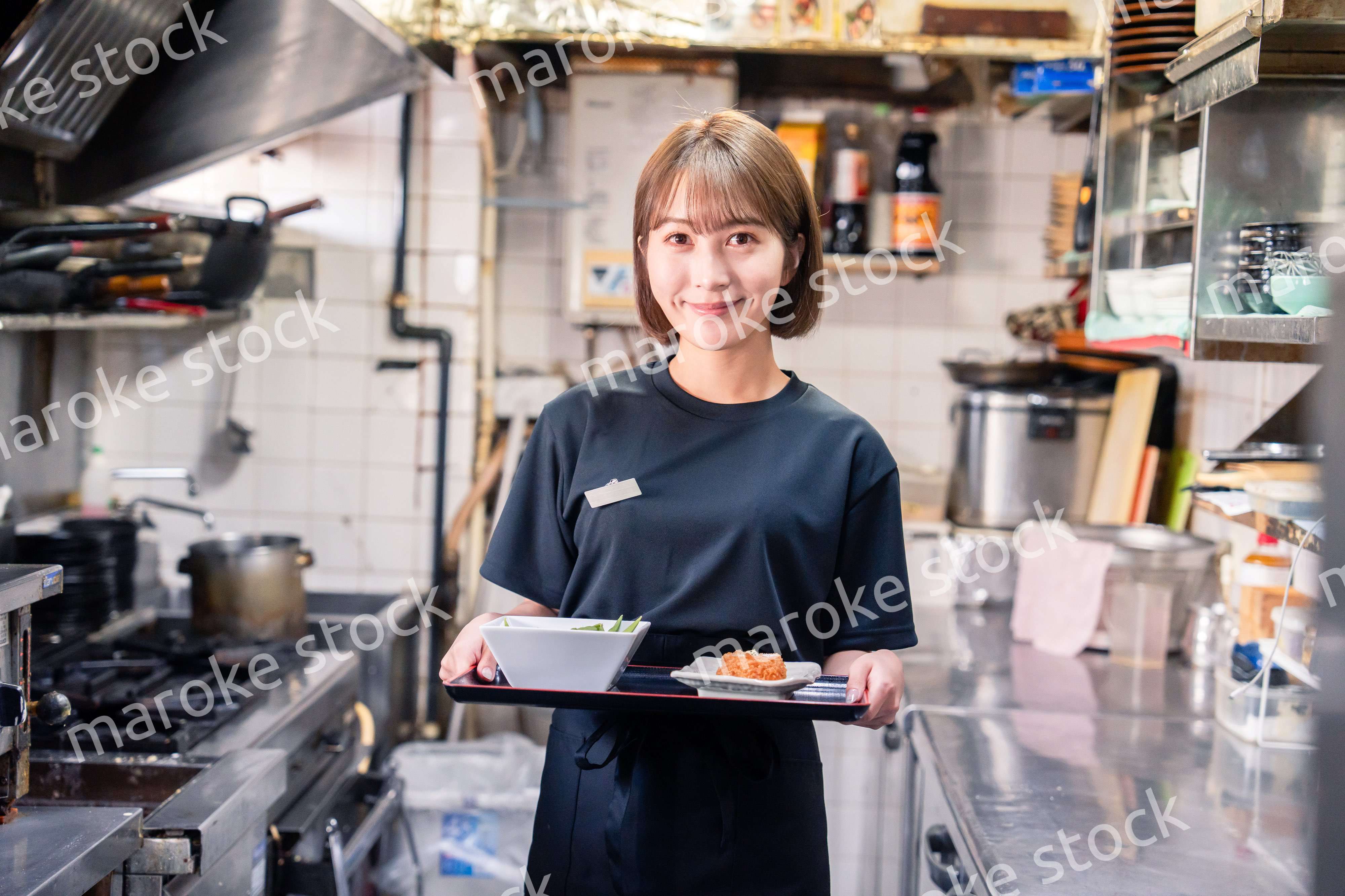 飲食店の厨房で働く若い女性のスタッフ