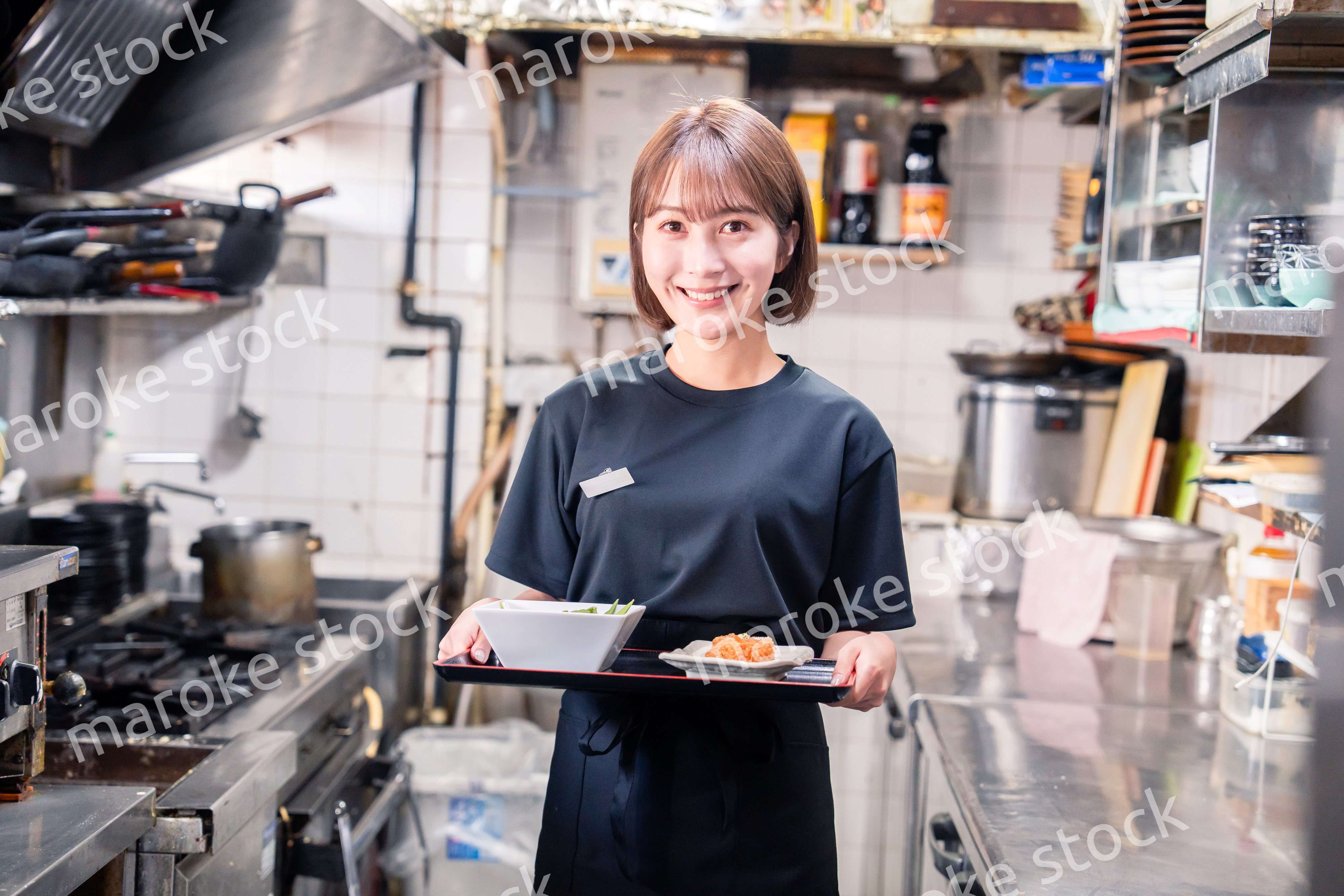 飲食店の厨房で働く若い女性のスタッフ