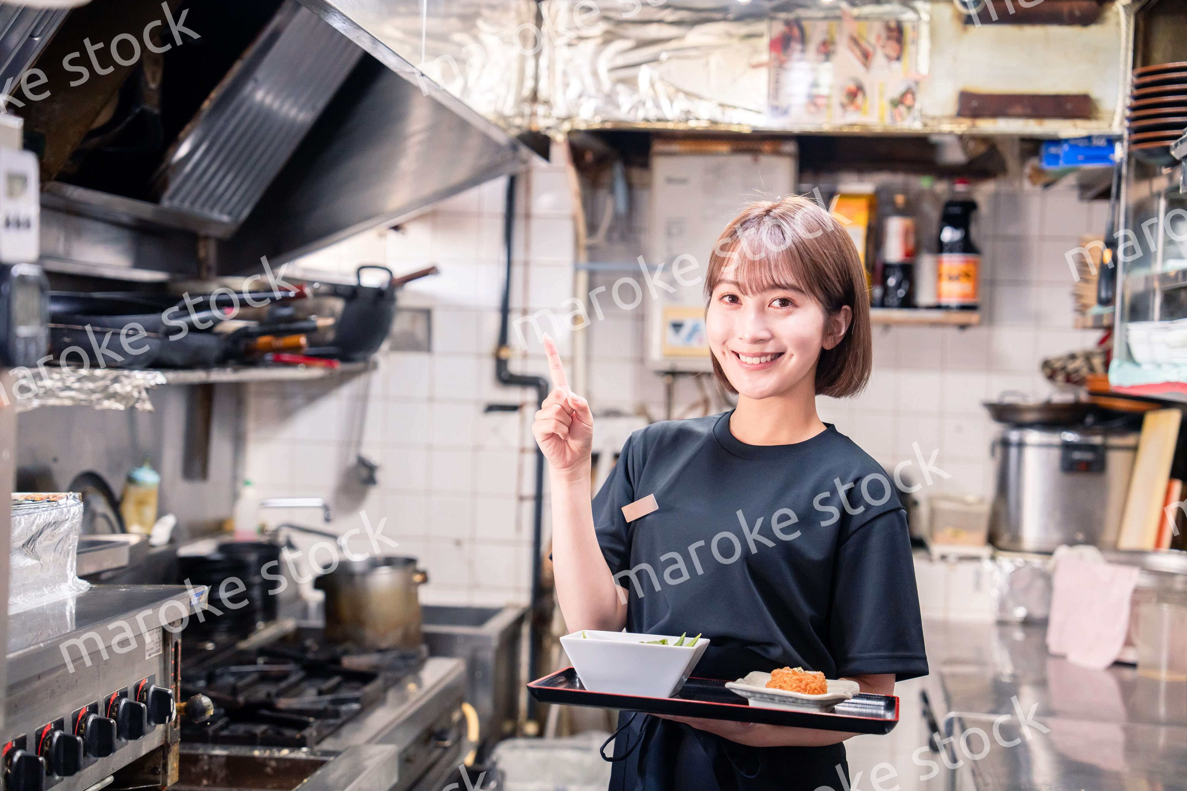 飲食店の厨房で働く若い女性のスタッフ