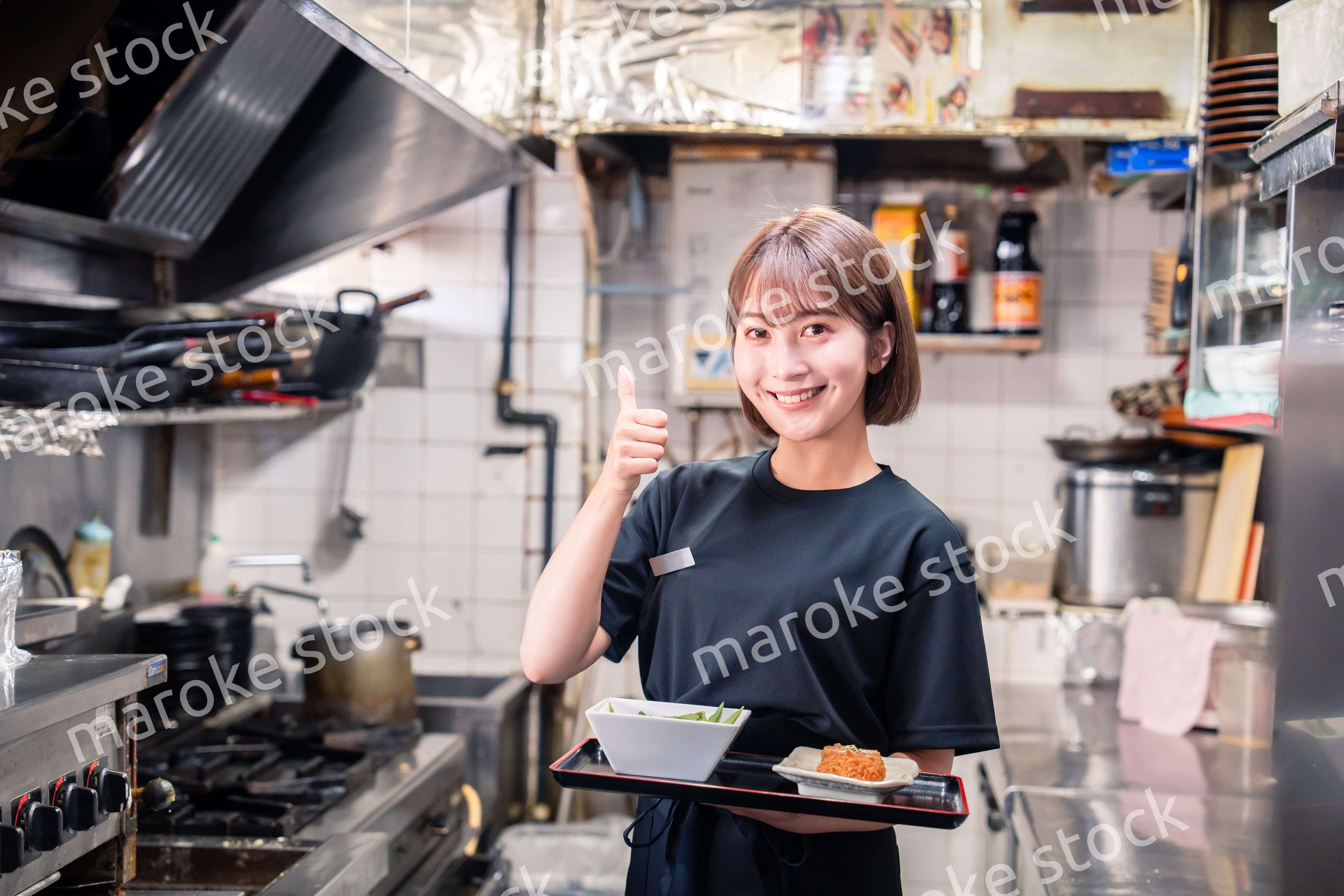 飲食店の厨房で働く若い女性のスタッフ