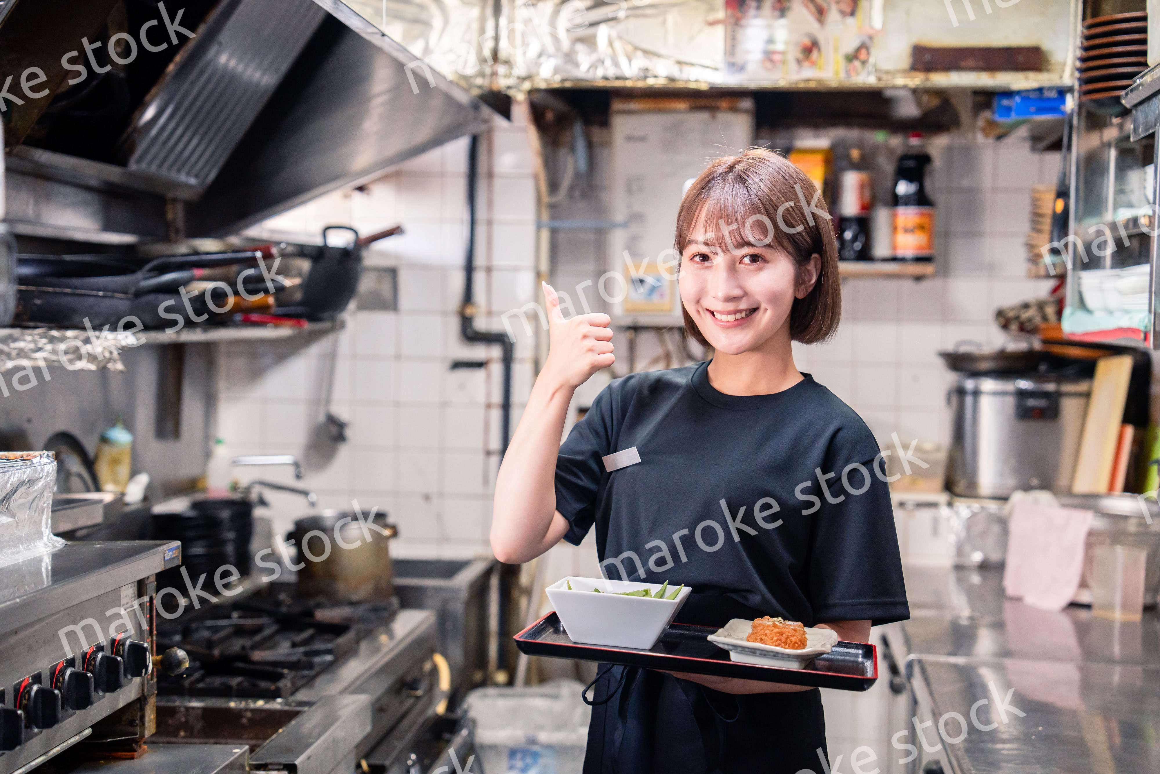 飲食店の厨房で働く若い女性のスタッフ