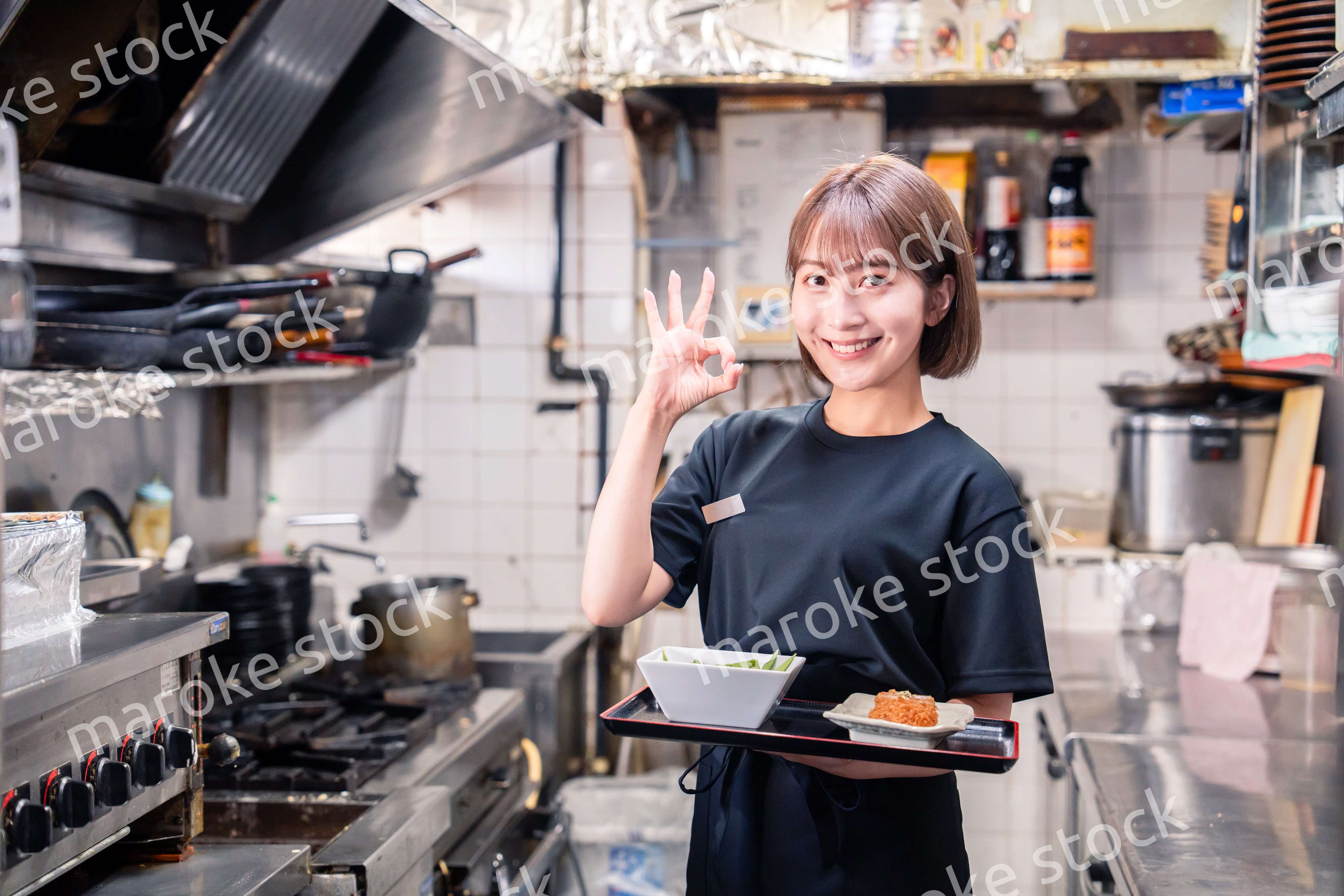 飲食店の厨房で働く若い女性のスタッフ