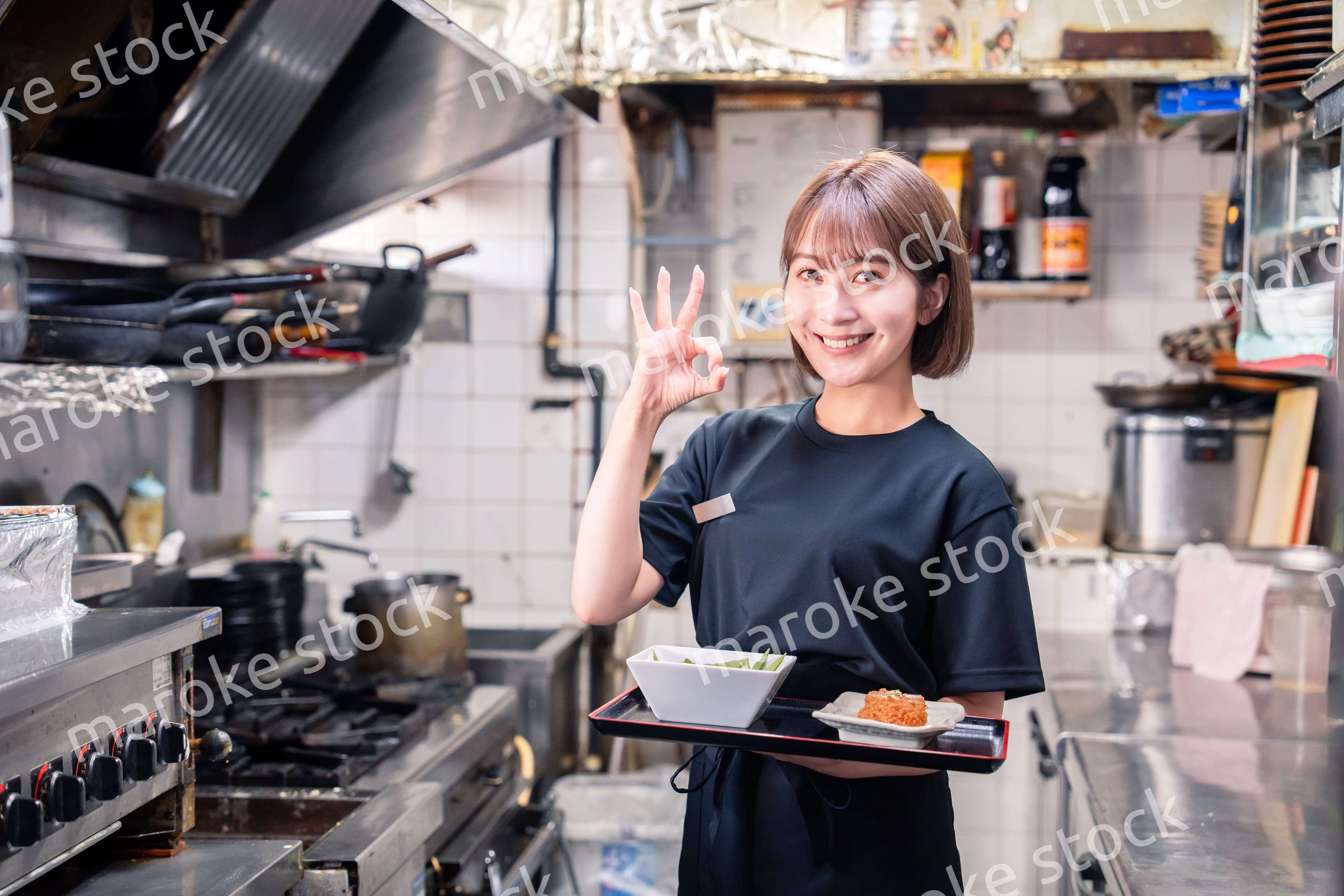 飲食店の厨房で働く若い女性のスタッフ