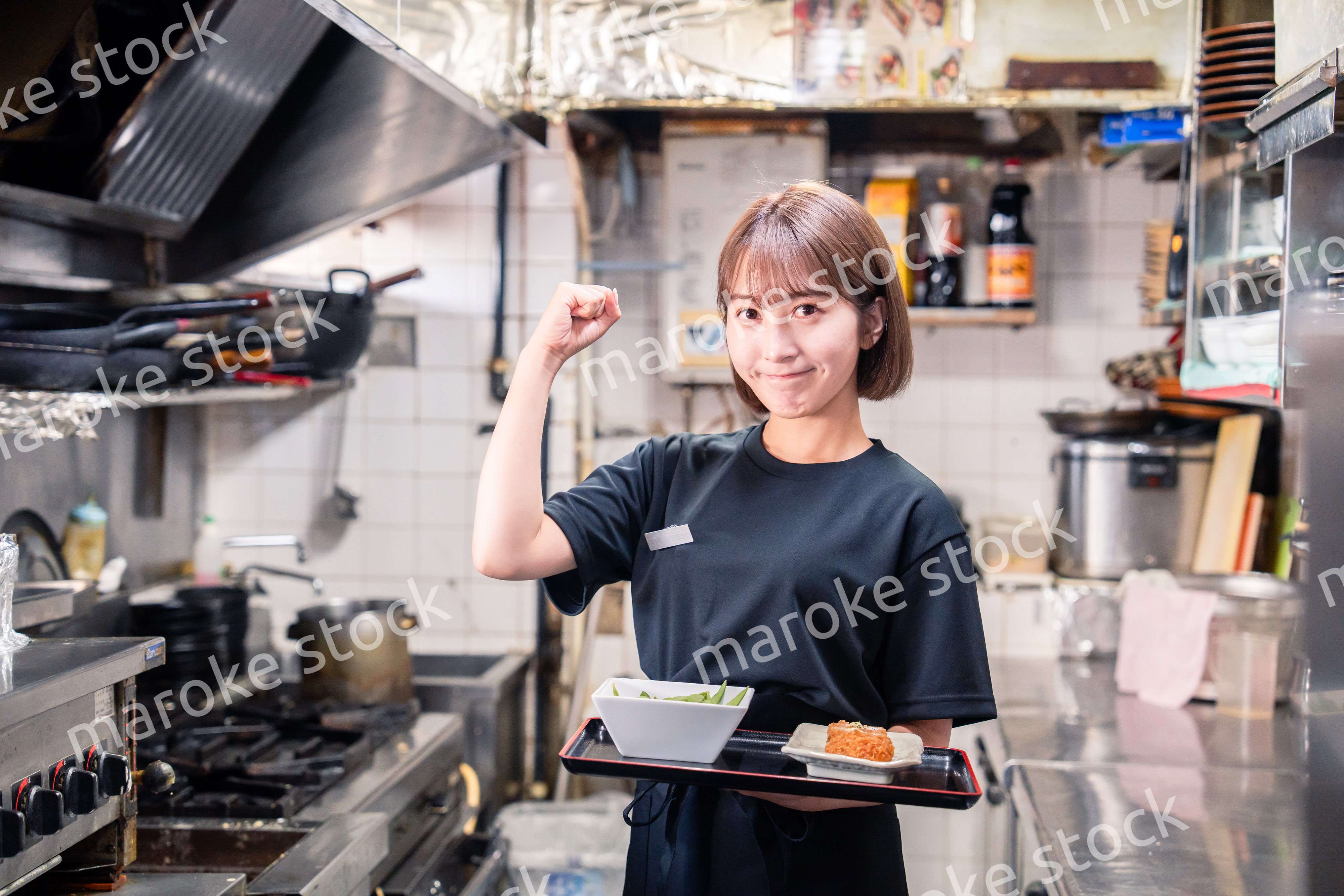 飲食店の厨房で働く若い女性のスタッフ