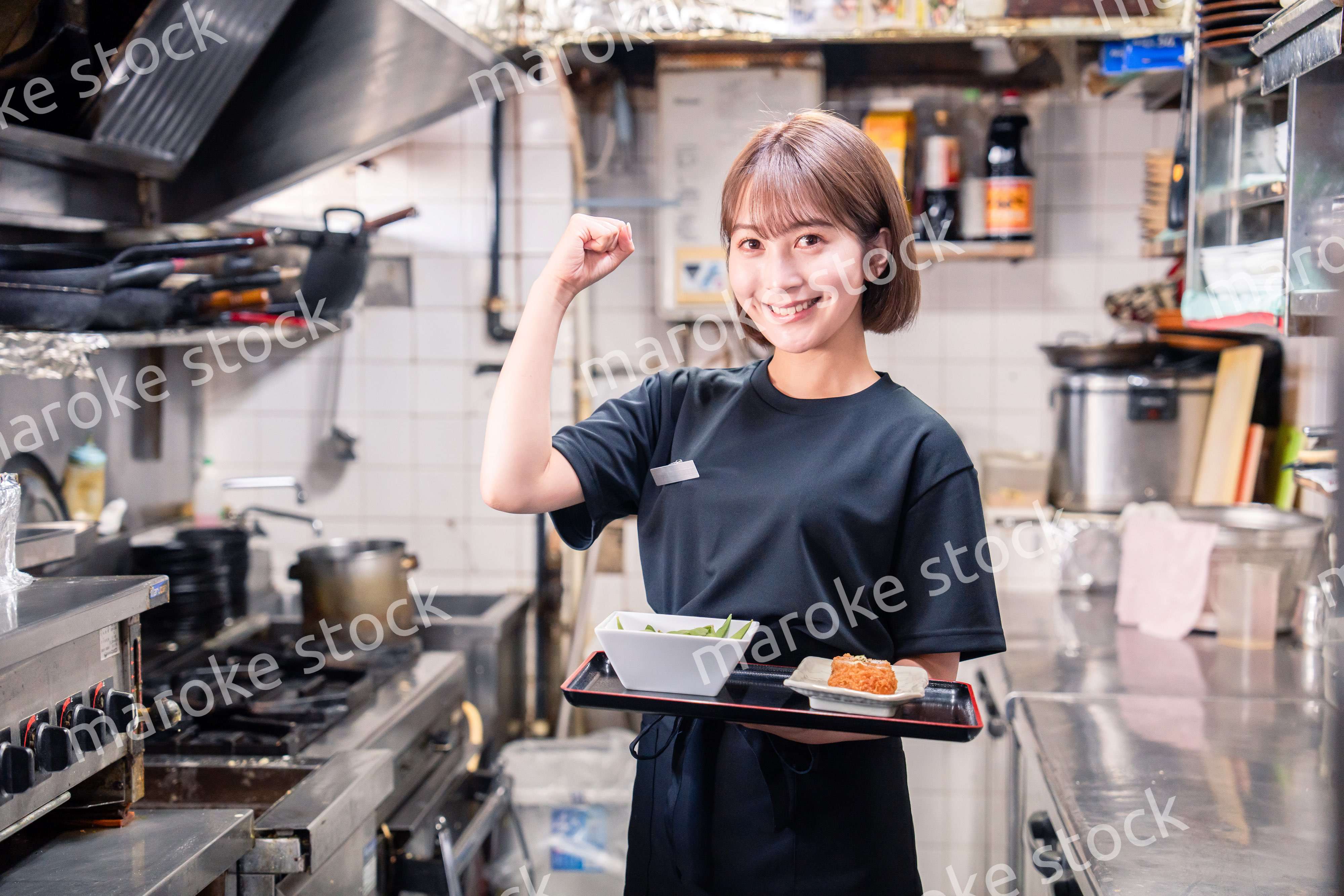 飲食店の厨房で働く若い女性のスタッフ