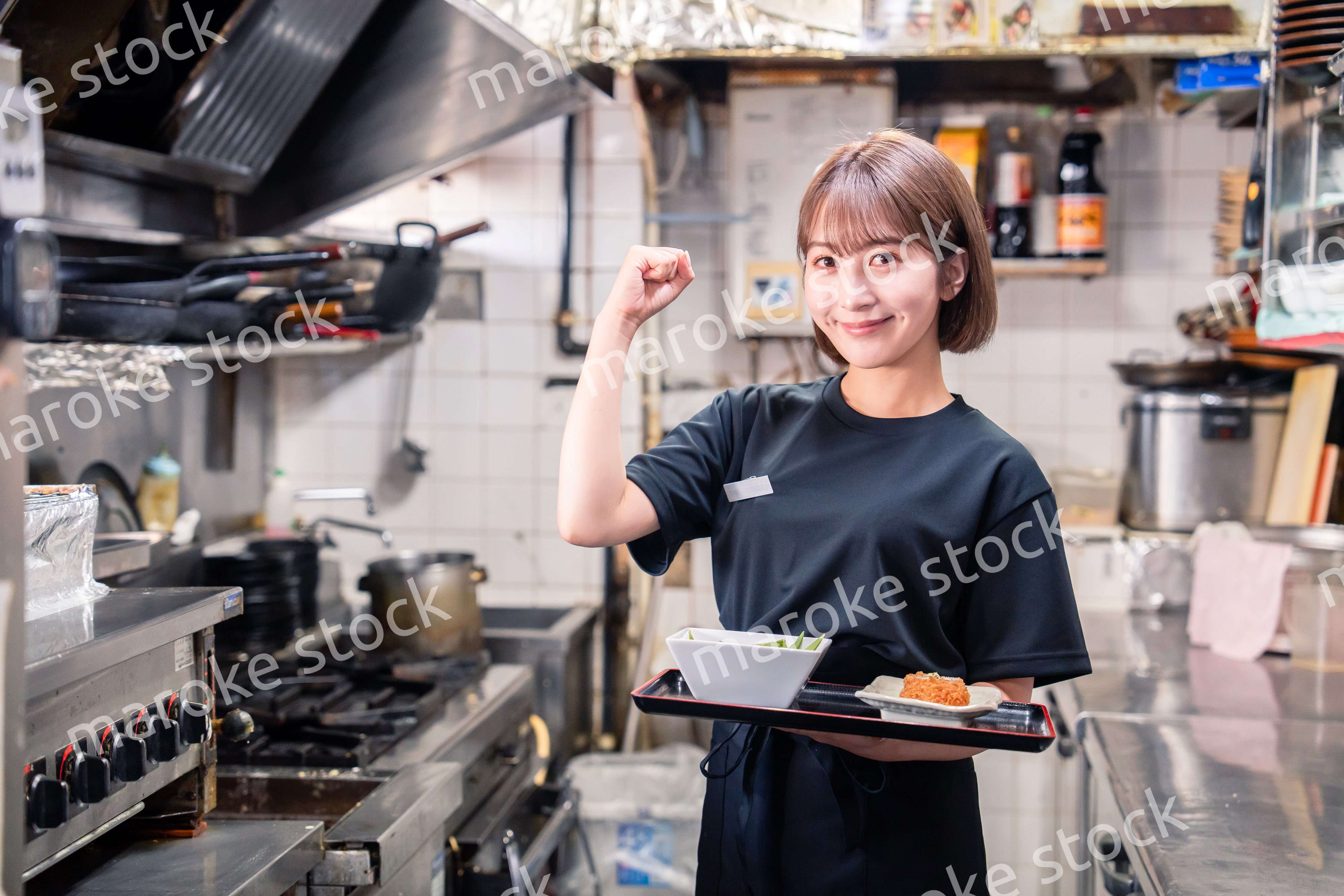 飲食店の厨房で働く若い女性のスタッフ