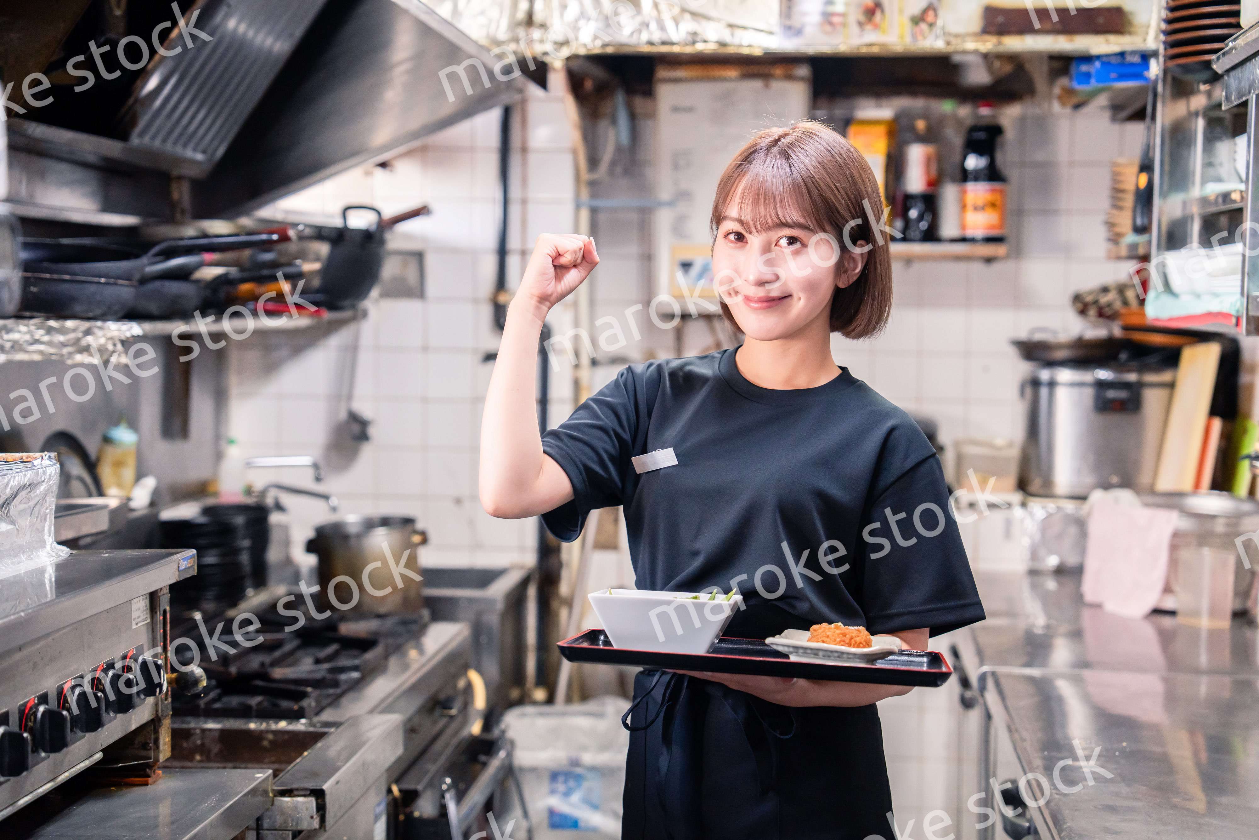 飲食店の厨房で働く若い女性のスタッフ