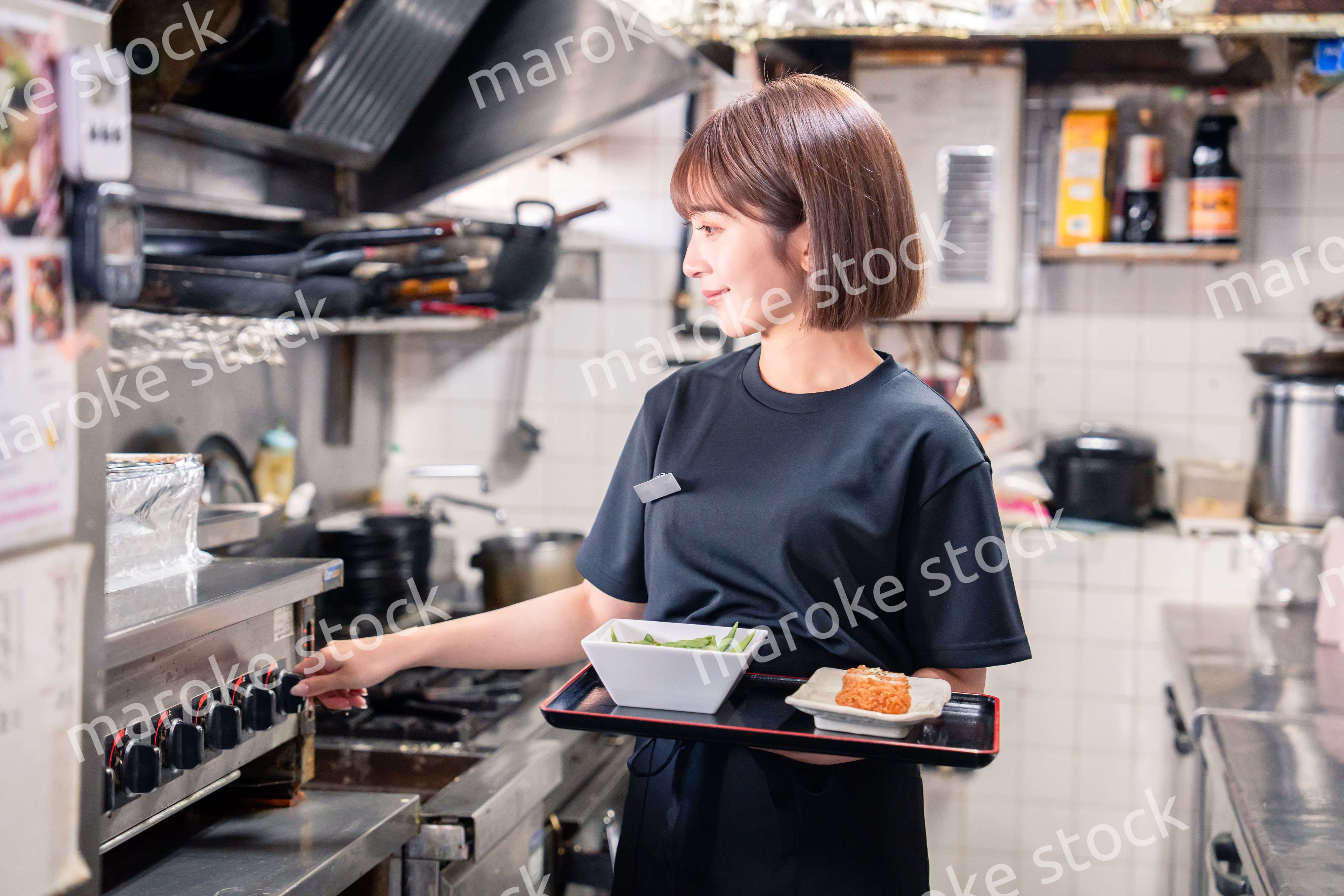 飲食店の厨房で働く若い女性のスタッフ