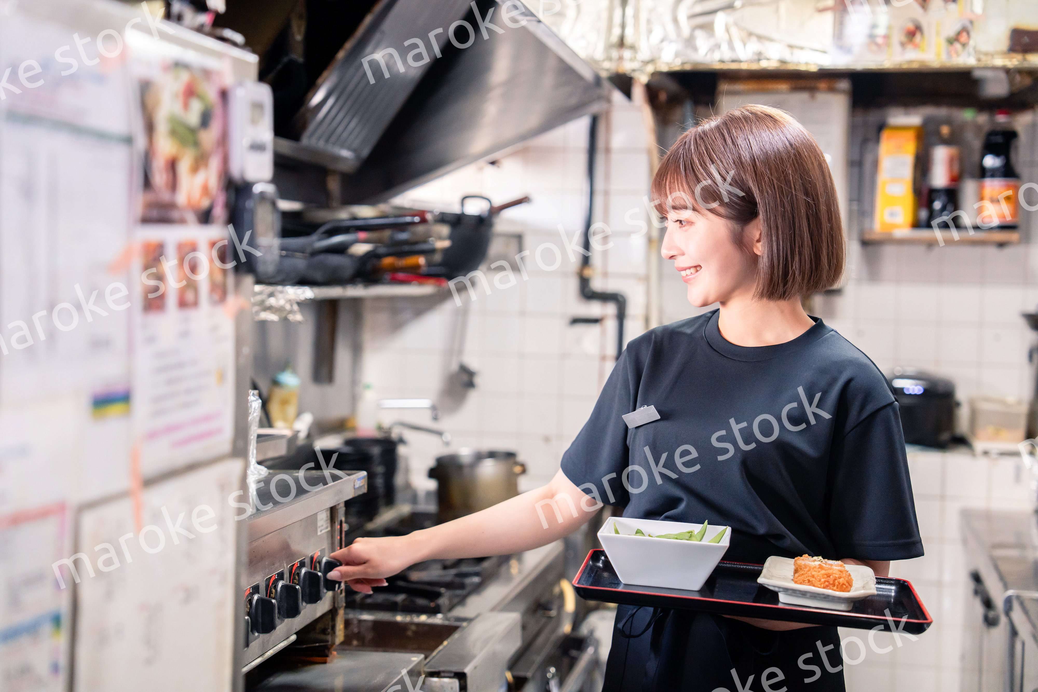 飲食店の厨房で働く若い女性のスタッフ