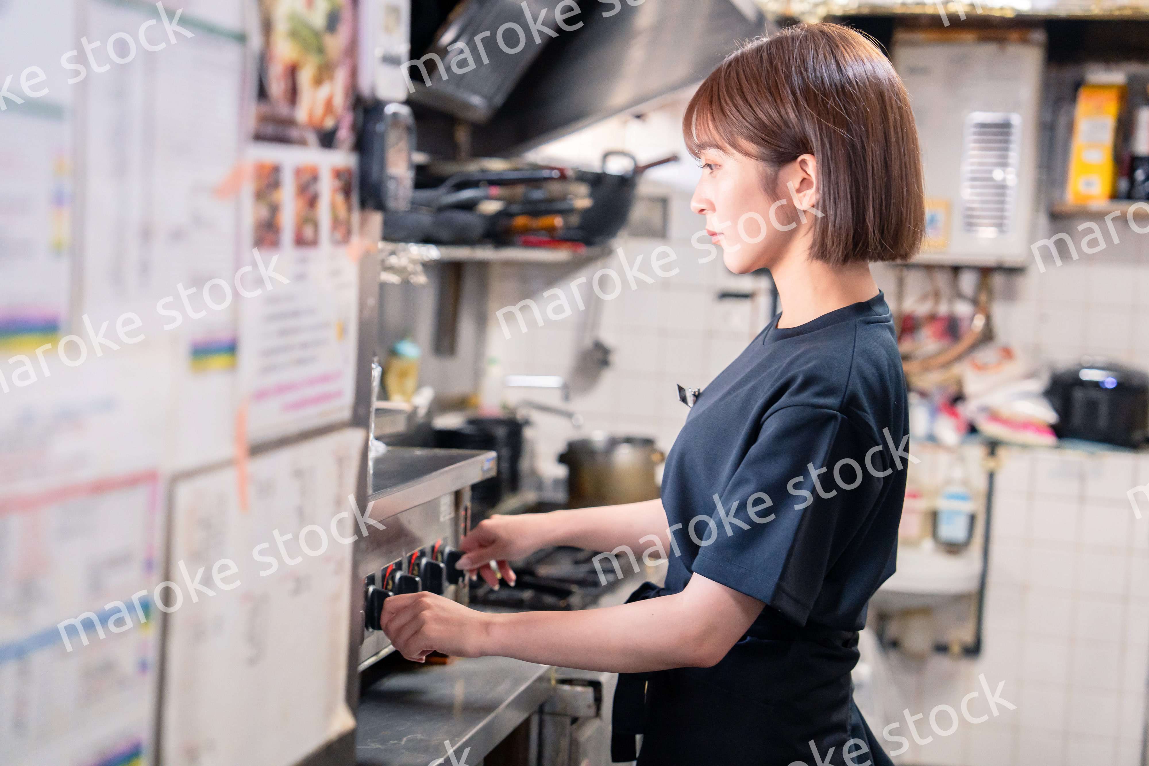 居酒屋の厨房で働くキッチンスタッフの女性