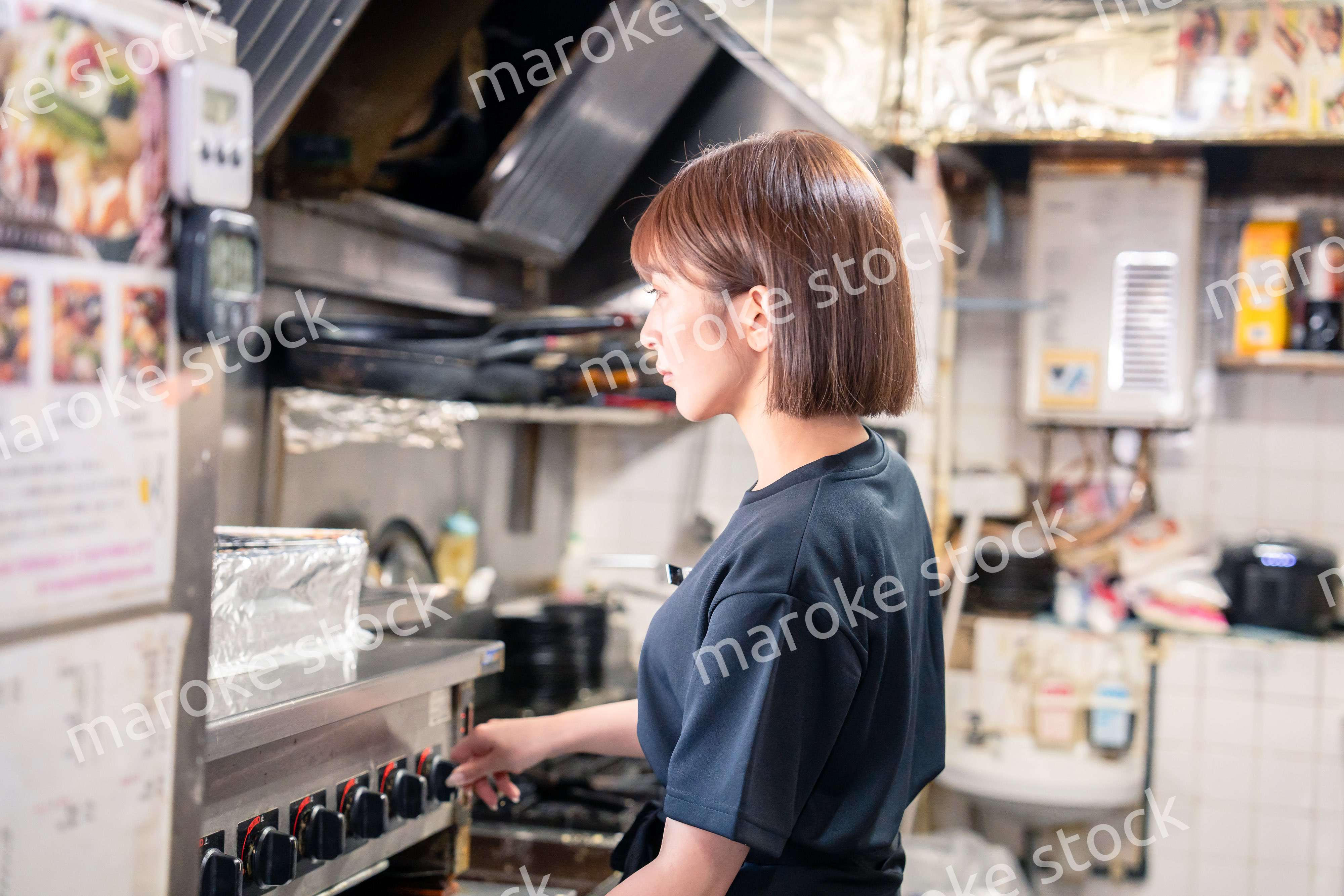 居酒屋の厨房で働くキッチンスタッフの女性