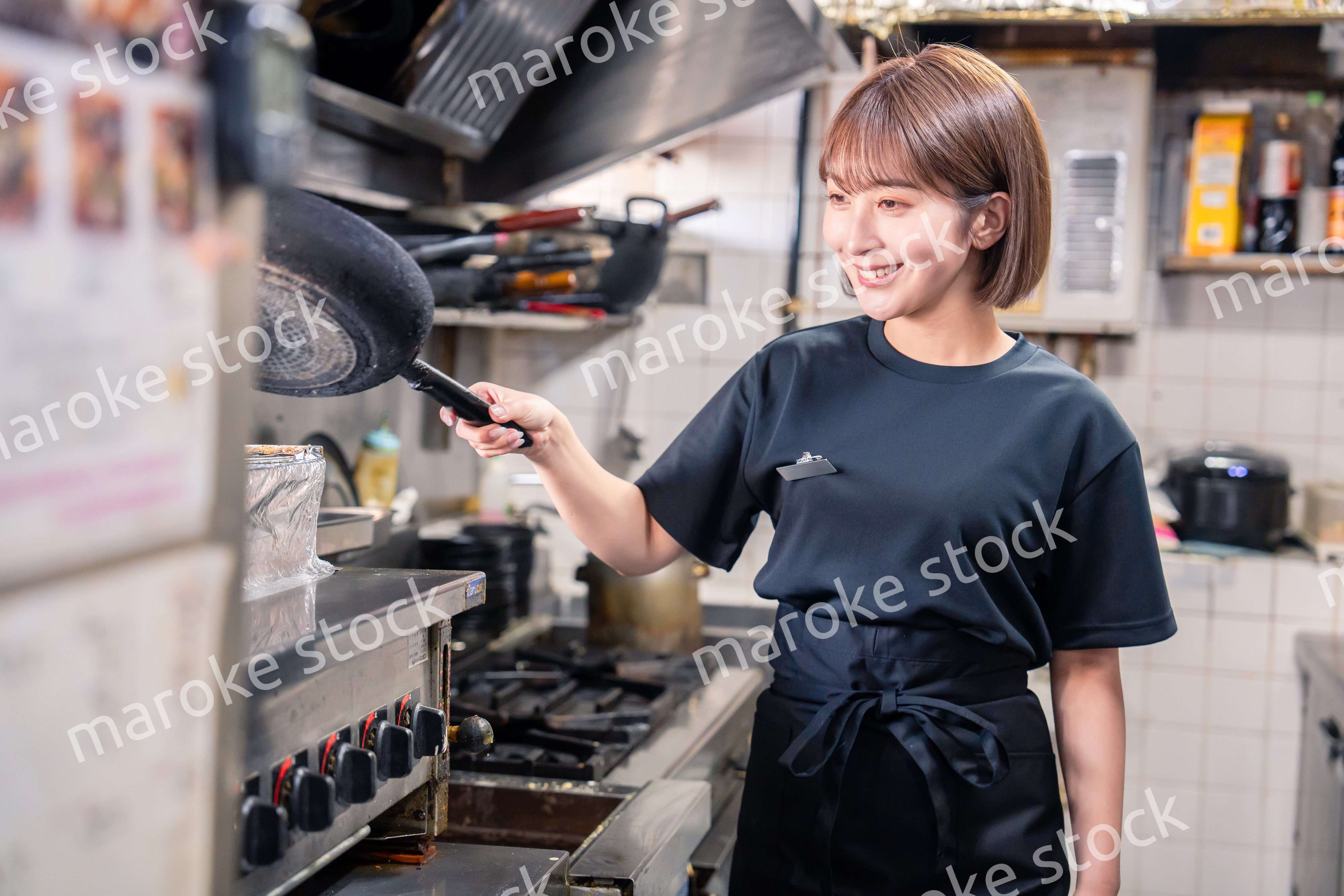 居酒屋の厨房で働くキッチンスタッフの女性