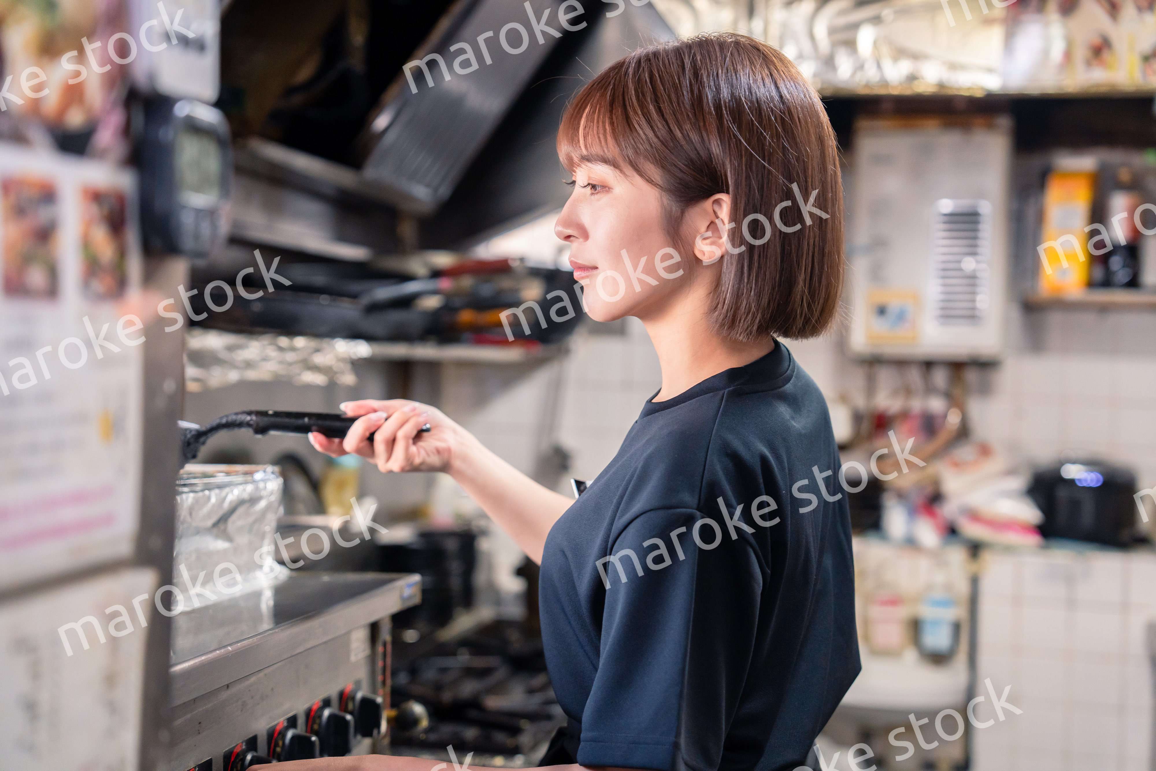 居酒屋の厨房で働くキッチンスタッフの女性