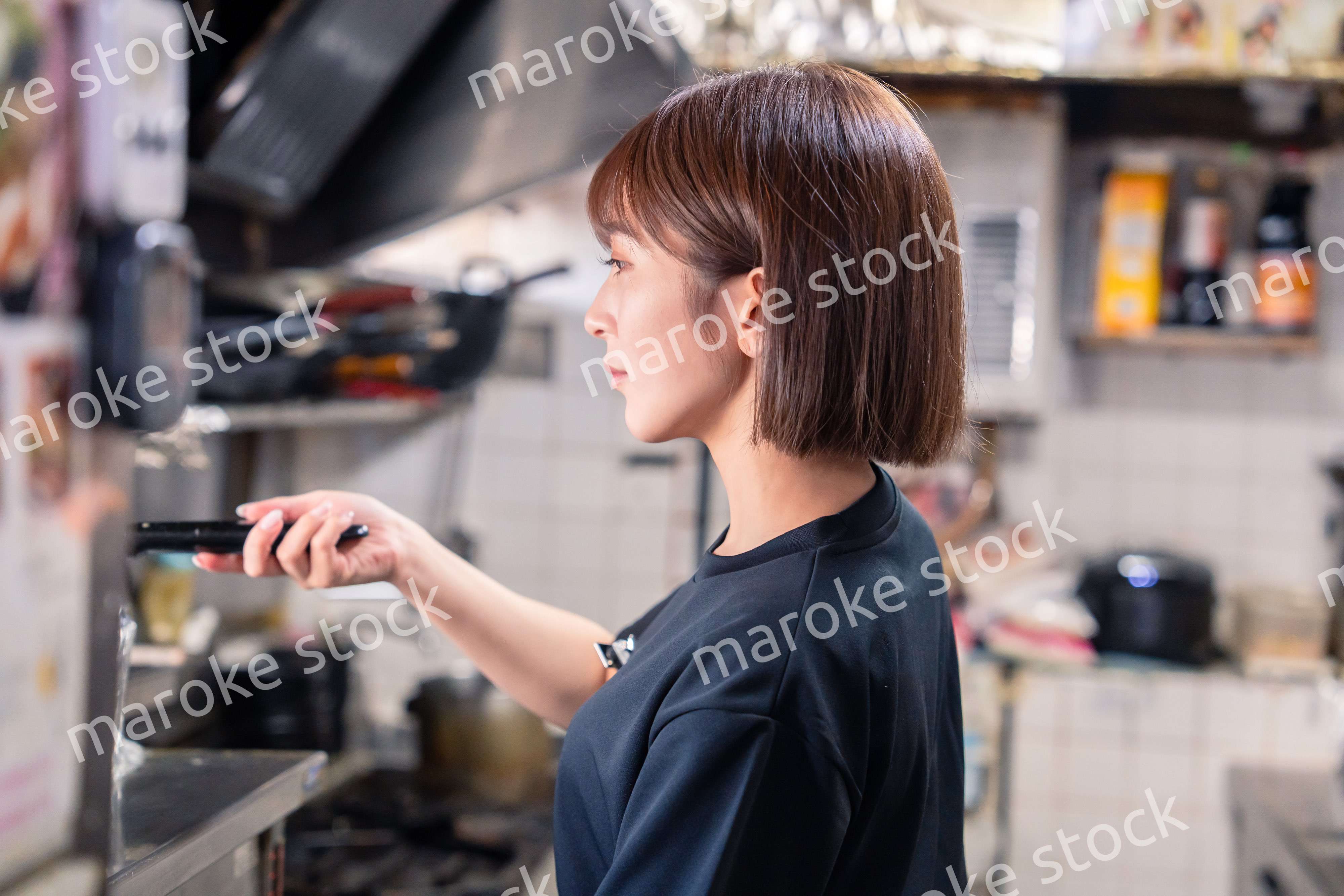 居酒屋の厨房で働くキッチンスタッフの女性