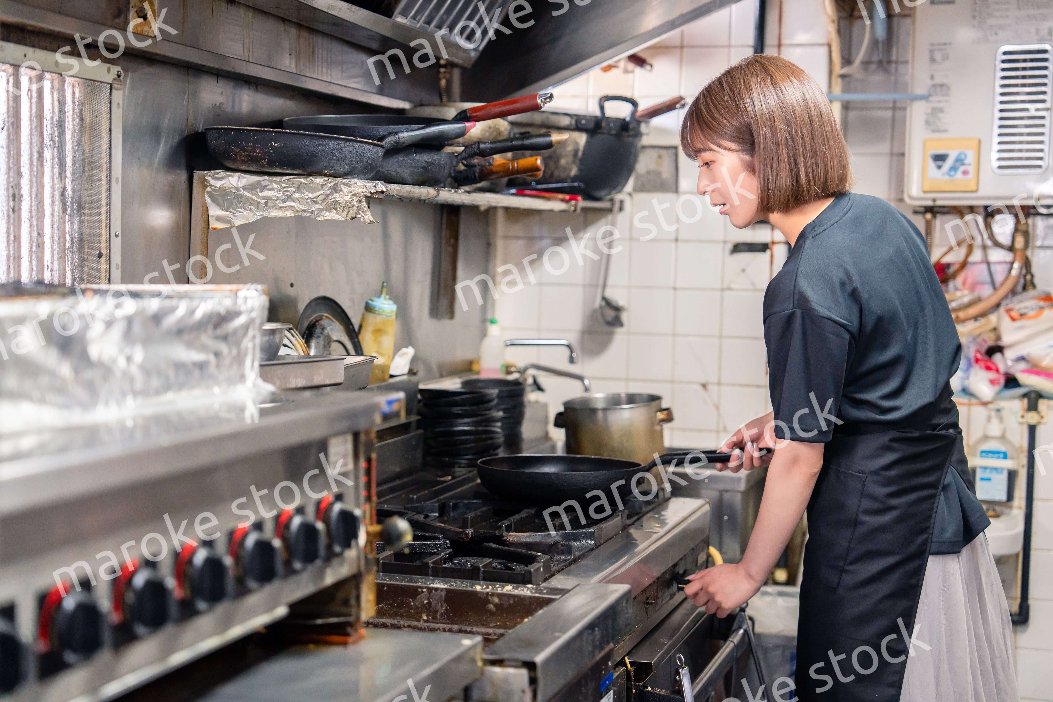 居酒屋の厨房で働くキッチンスタッフの女性