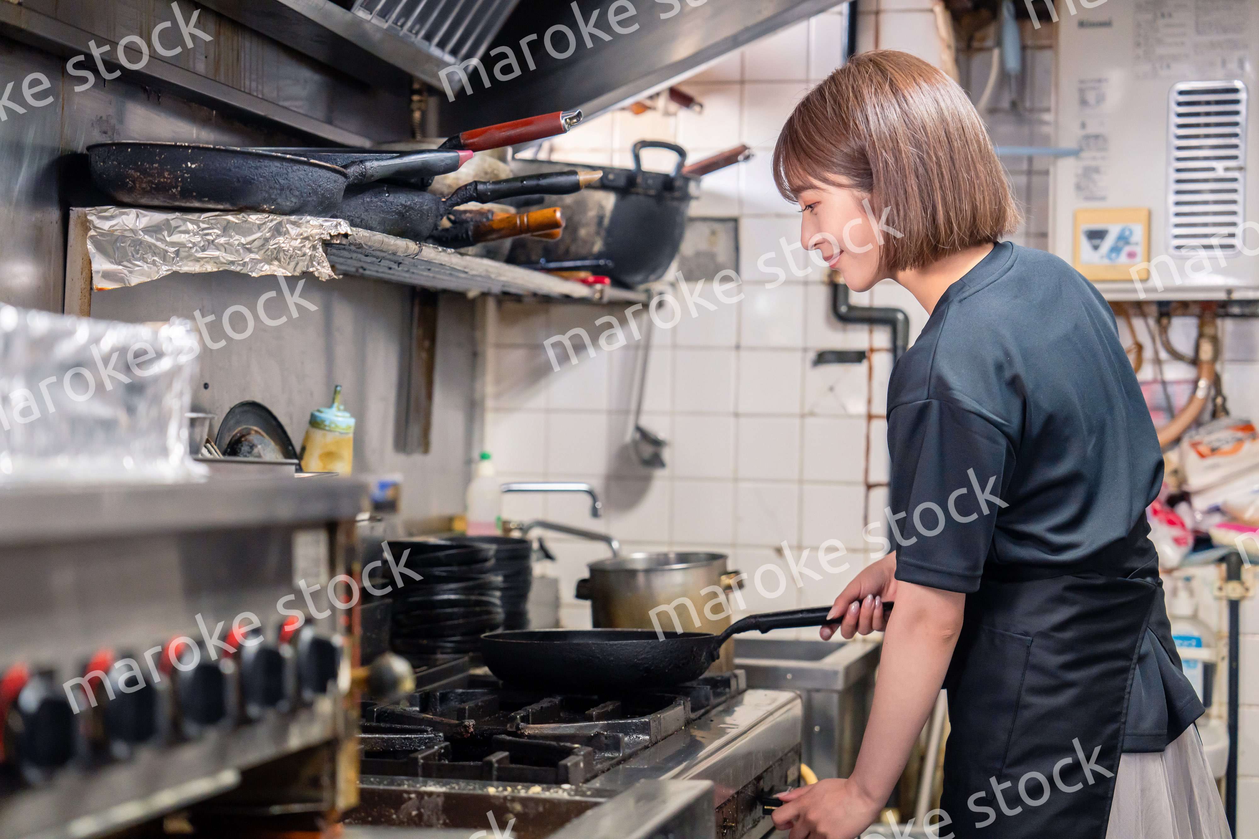 居酒屋の厨房で働くキッチンスタッフの女性