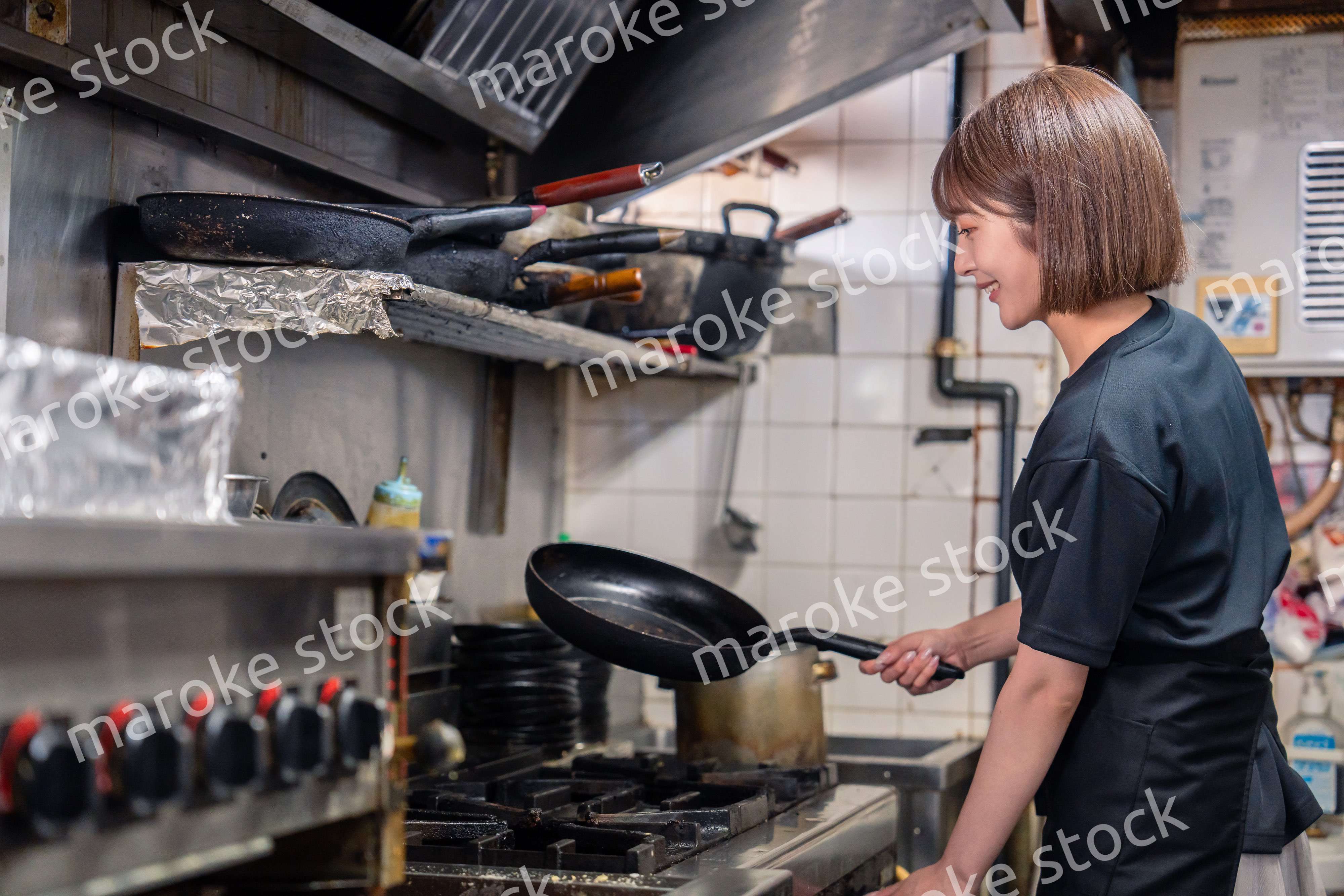 居酒屋の厨房で働くキッチンスタッフの女性