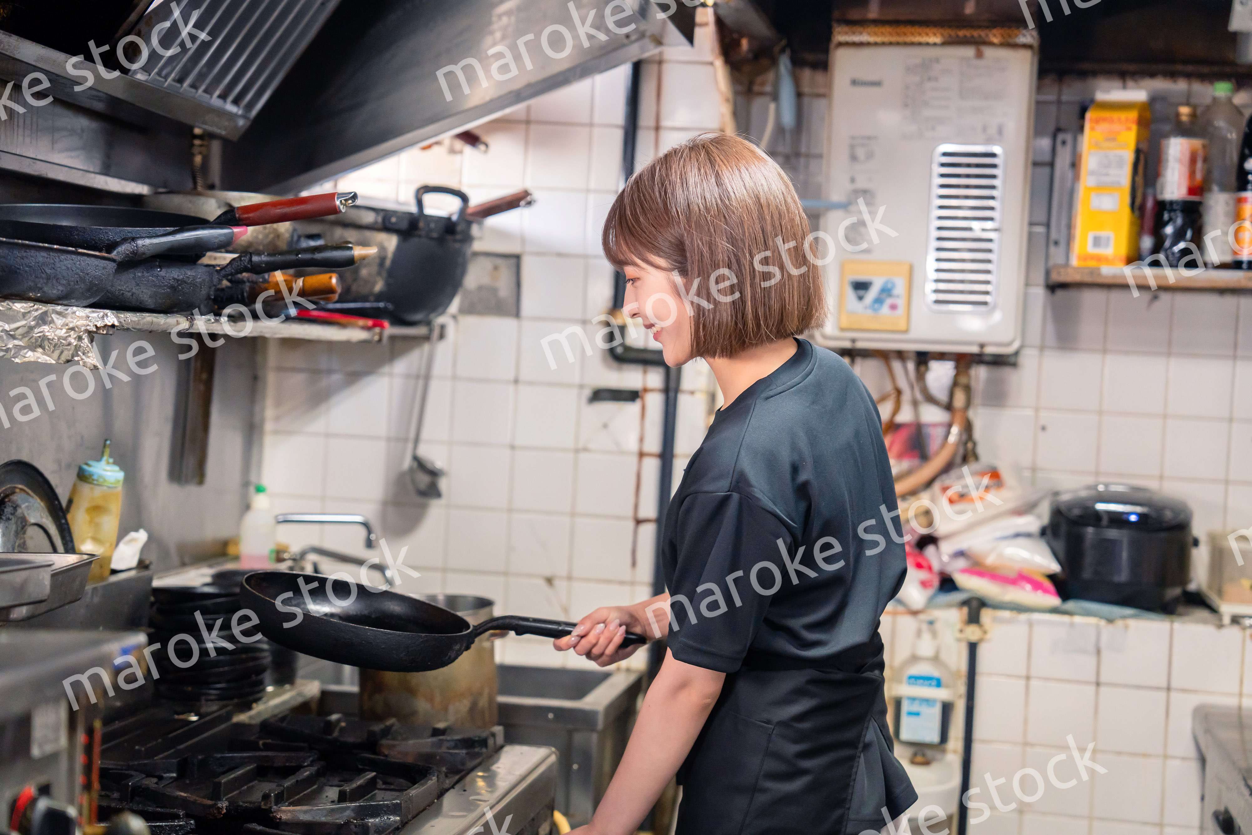 居酒屋の厨房で働くキッチンスタッフの女性