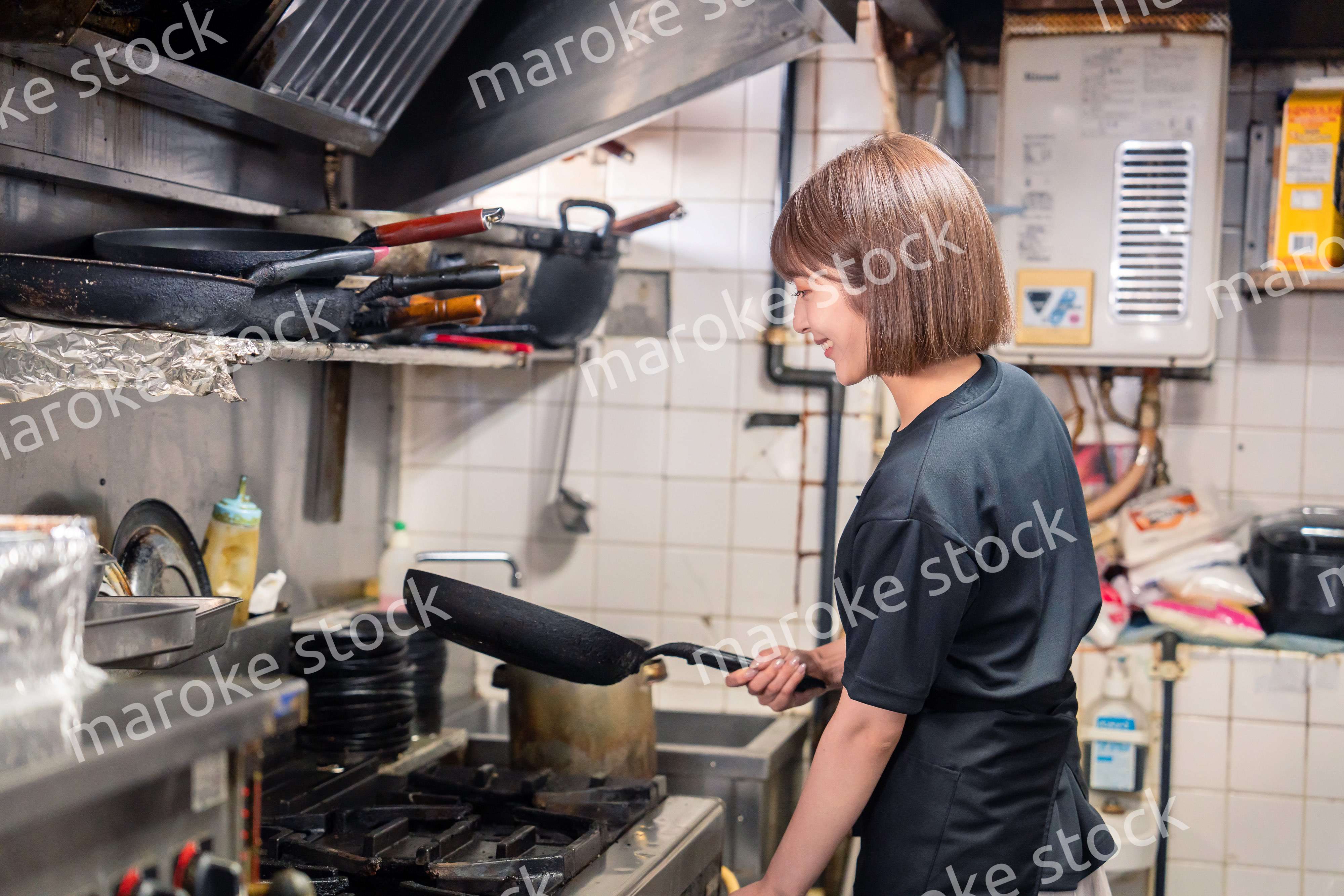 居酒屋の厨房で働くキッチンスタッフの女性