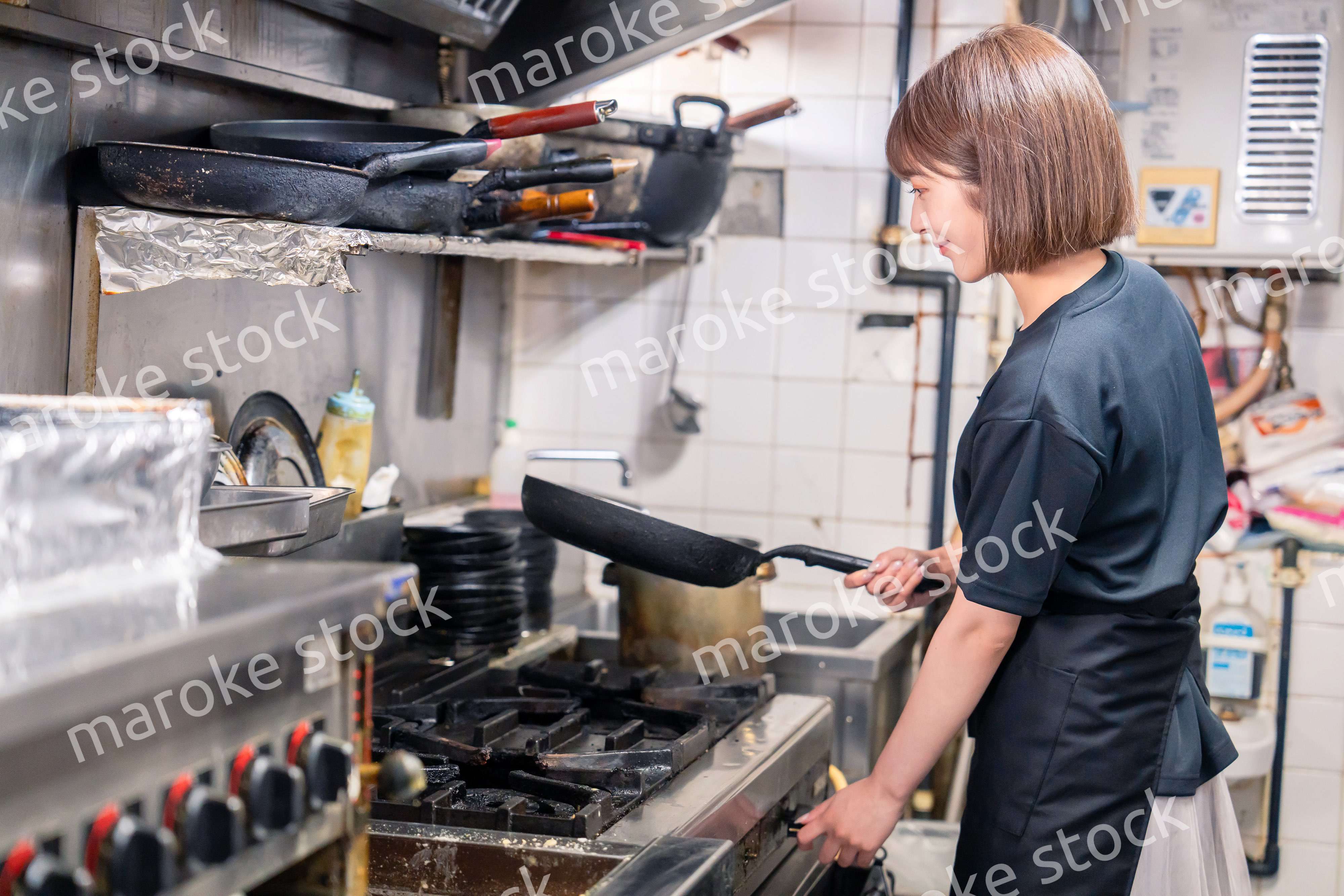居酒屋の厨房で働くキッチンスタッフの女性