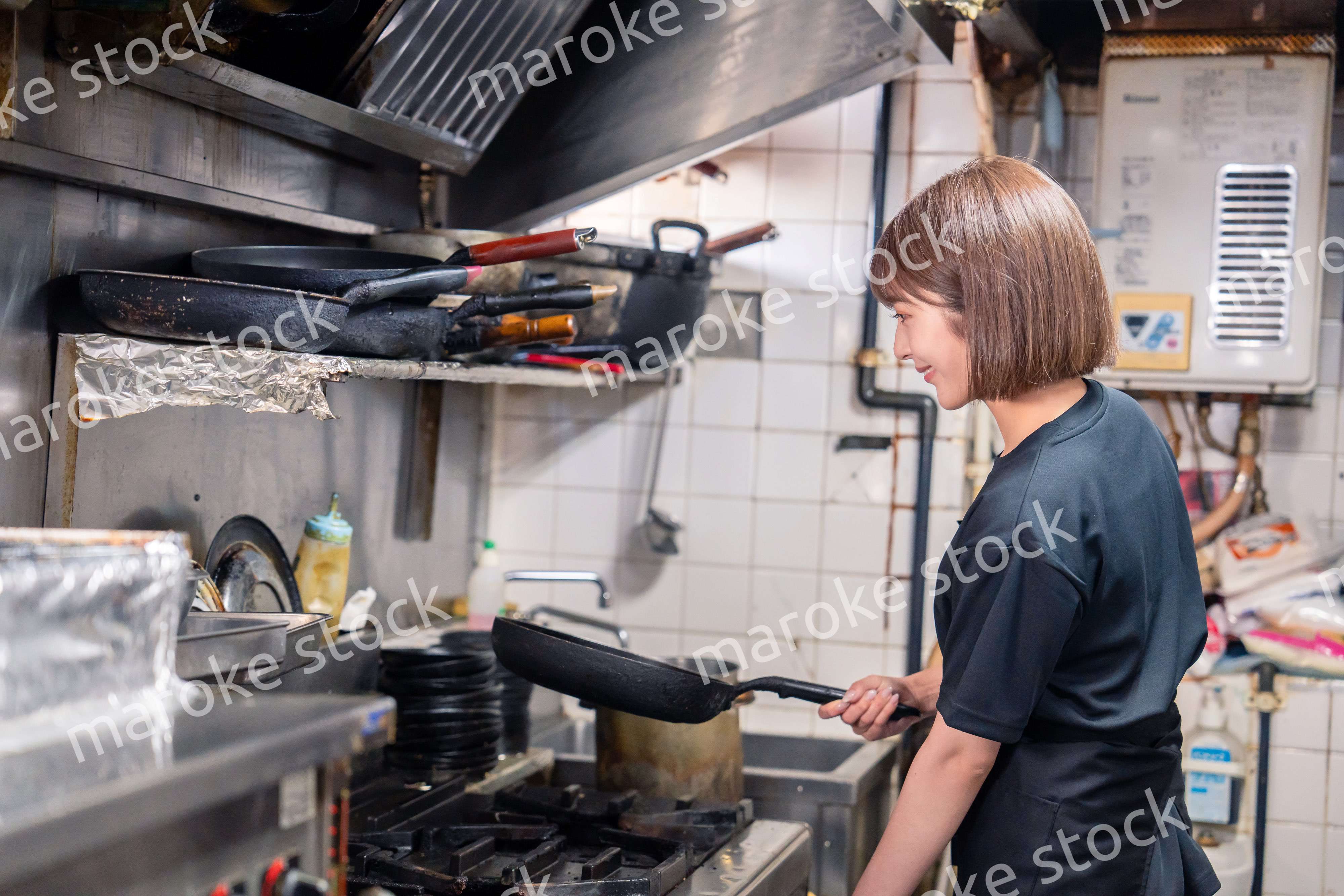 居酒屋の厨房で働くキッチンスタッフの女性