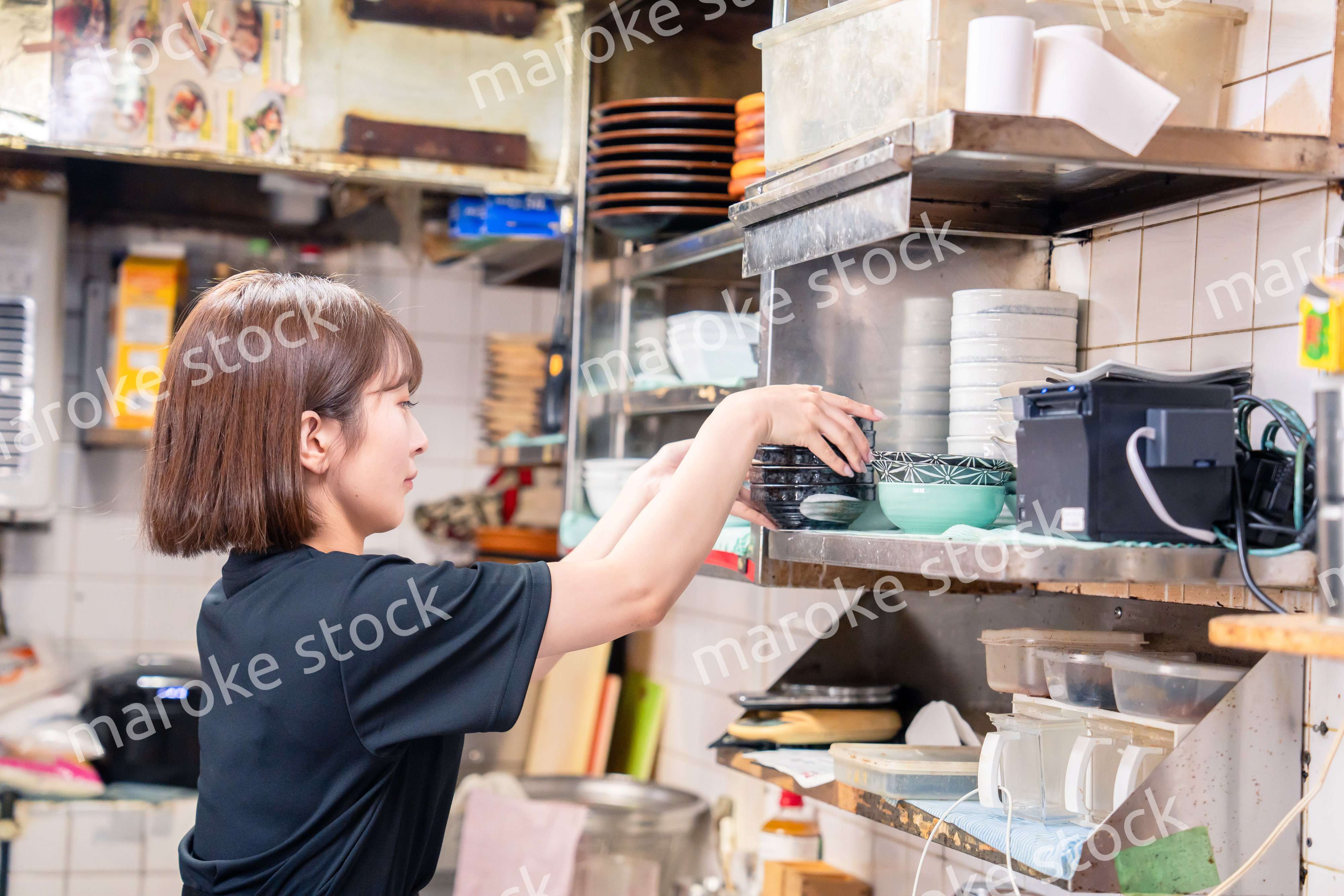 居酒屋の厨房で働くキッチンスタッフの女性