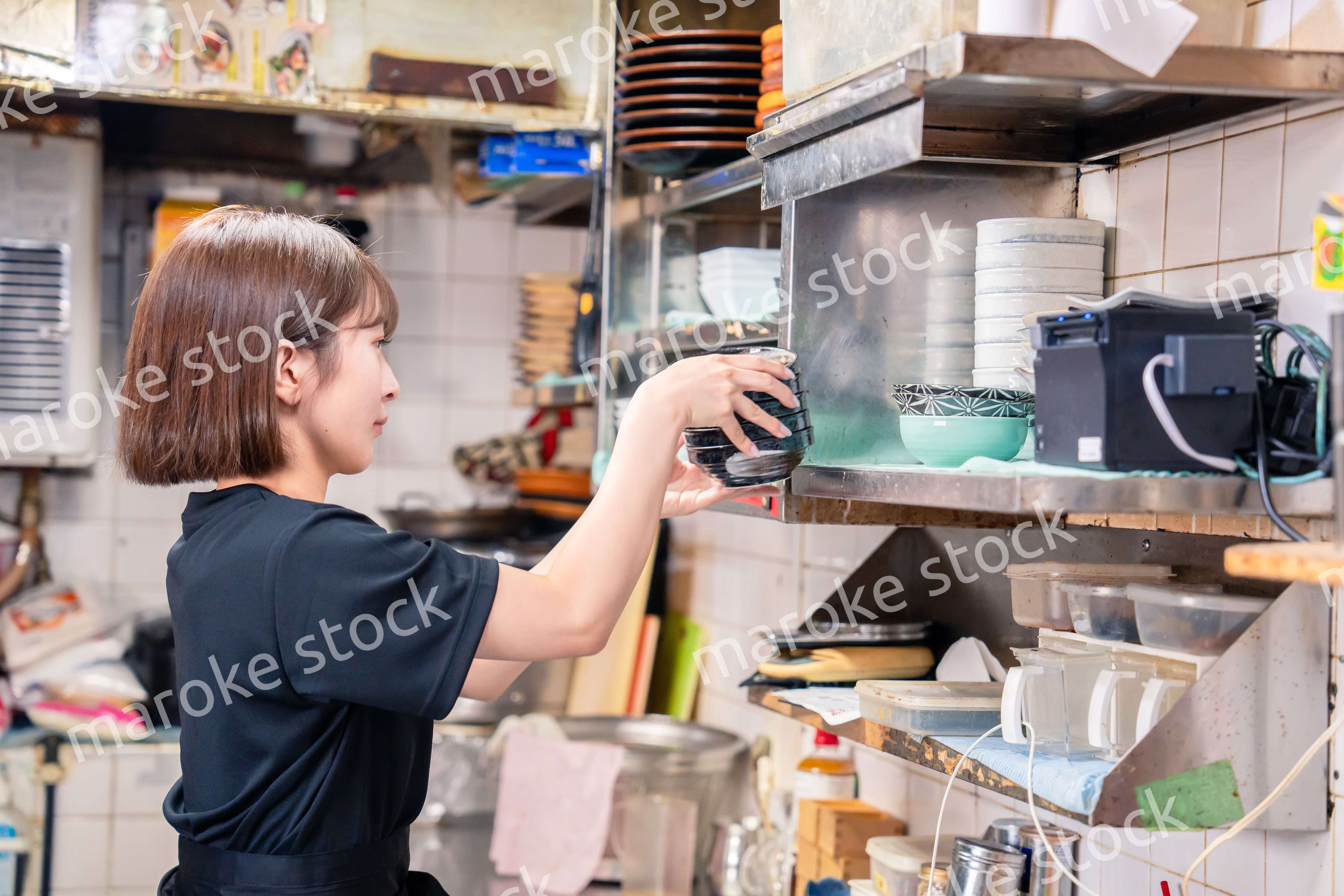 居酒屋の厨房で働くキッチンスタッフの女性
