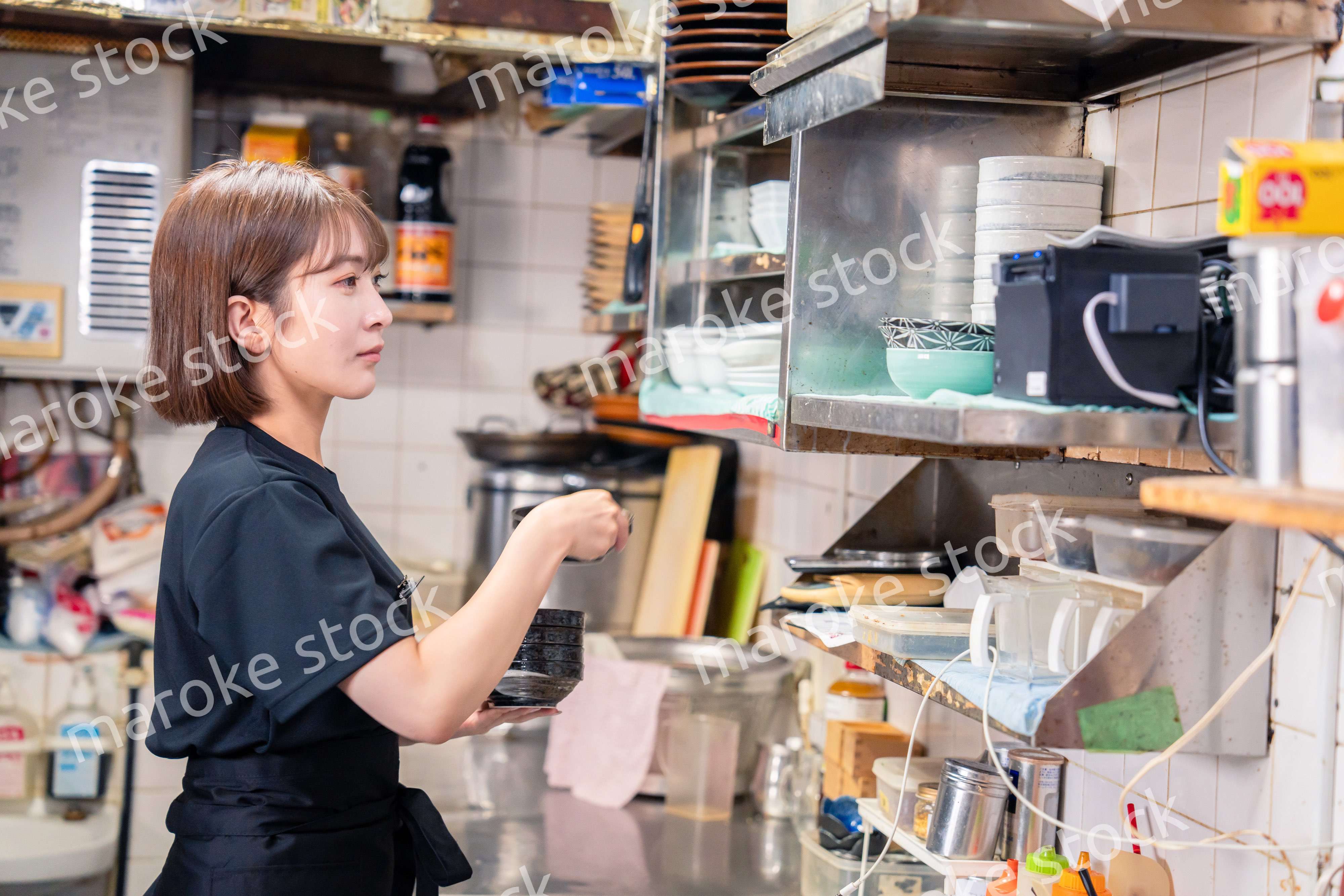 居酒屋の厨房で働くキッチンスタッフの女性