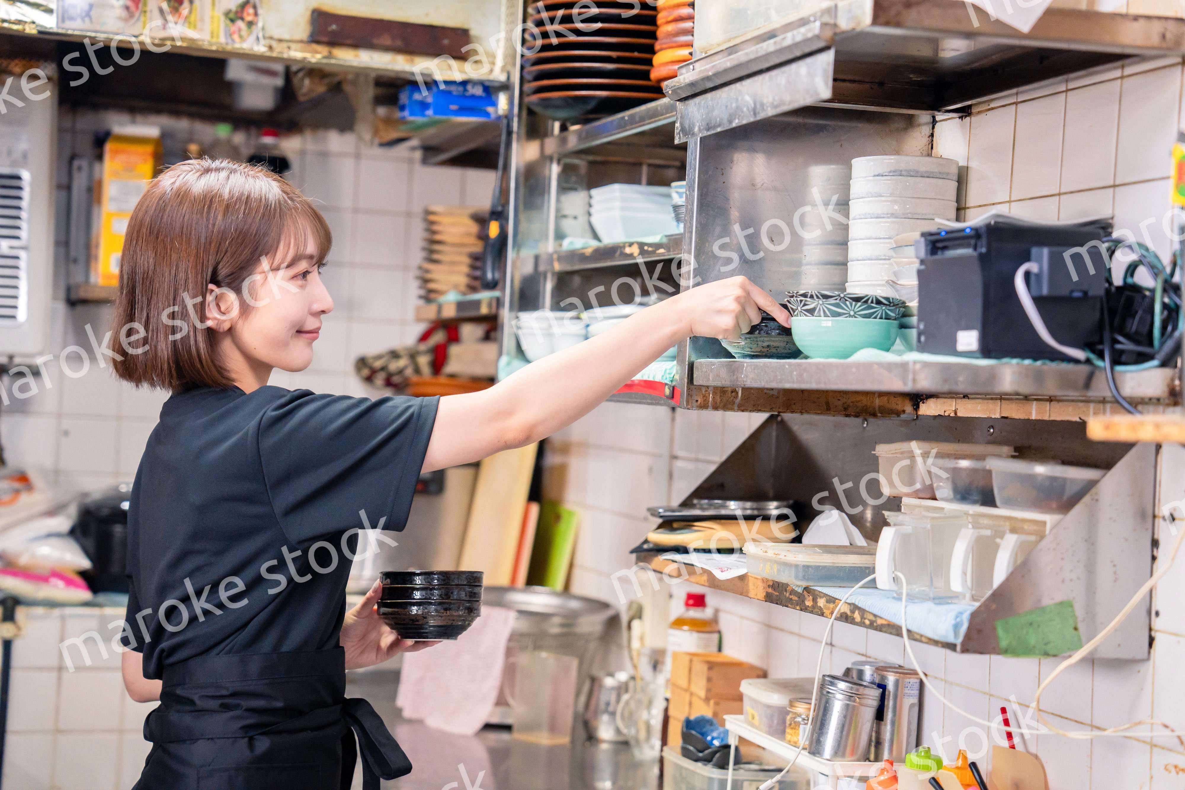 居酒屋の厨房で働くキッチンスタッフの女性