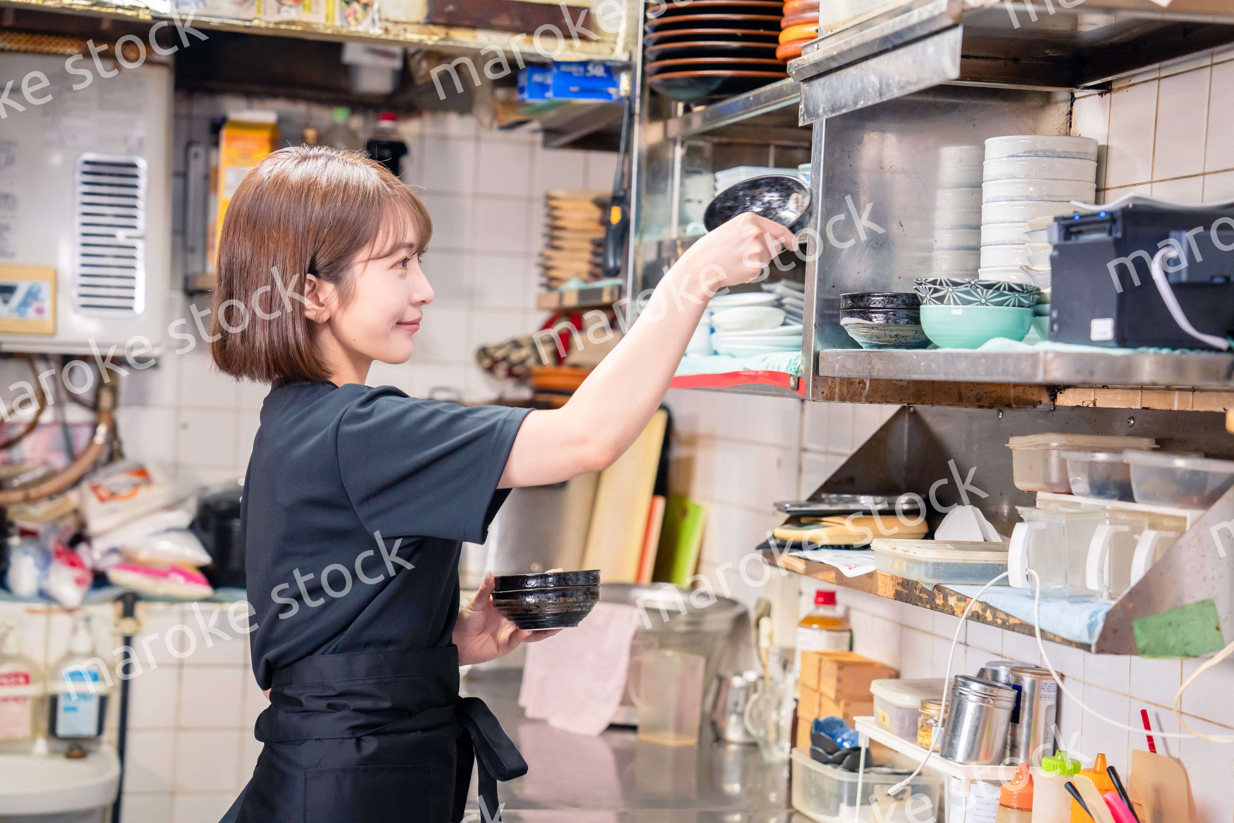 居酒屋の厨房で働くキッチンスタッフの女性
