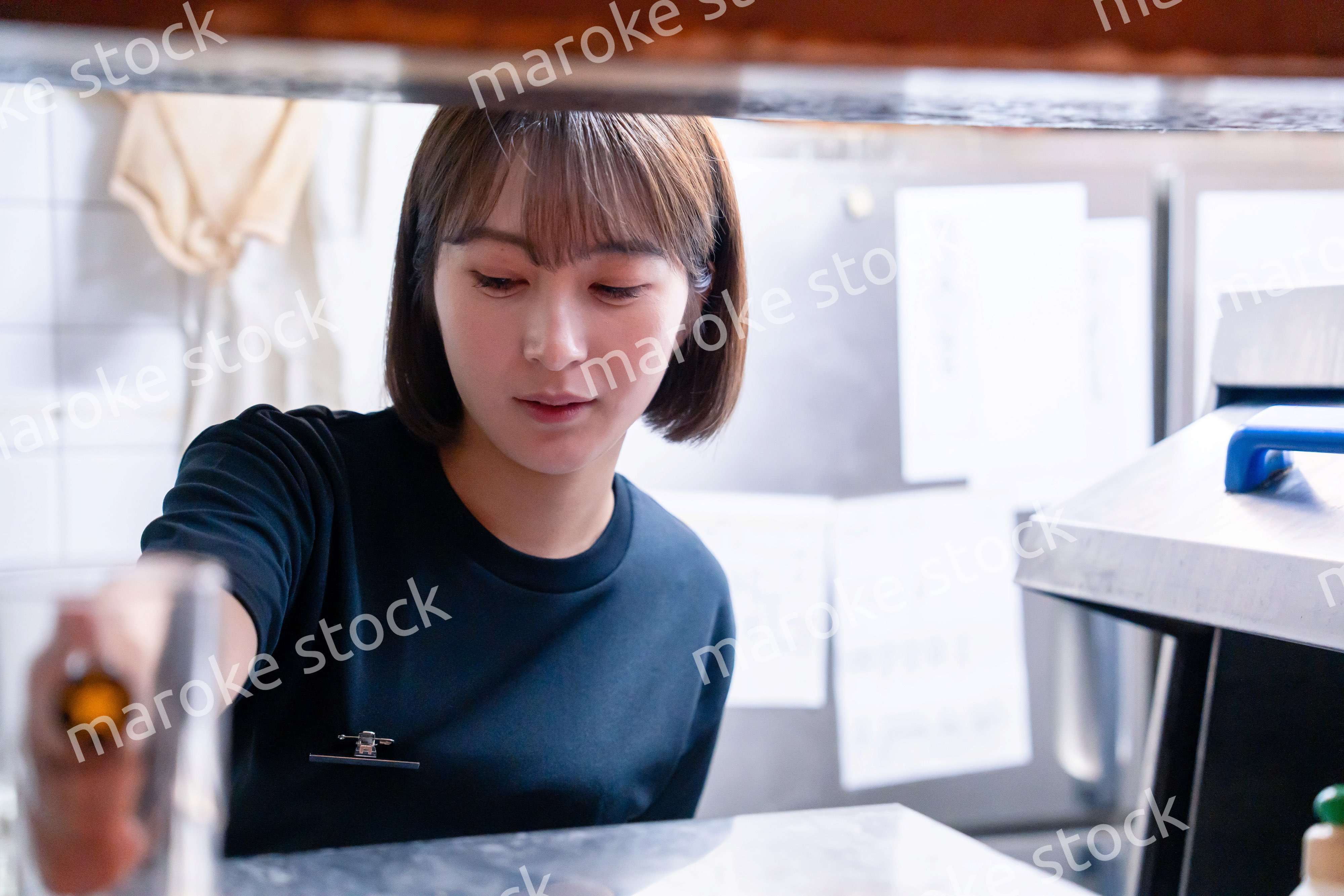 業務用の食洗機でお皿洗いをする飲食店スタッフ