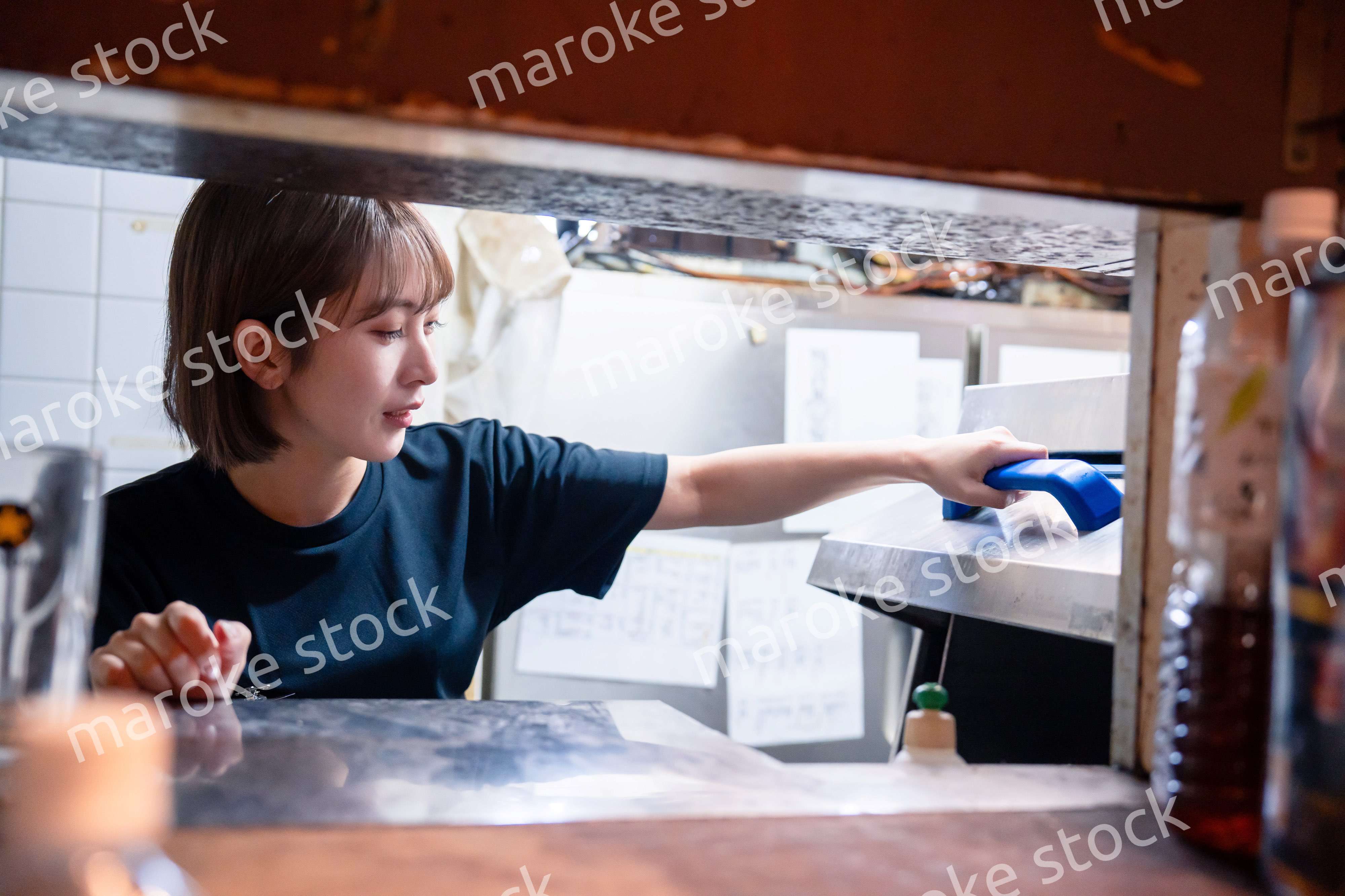 業務用の食洗機でお皿洗いをする飲食店スタッフ