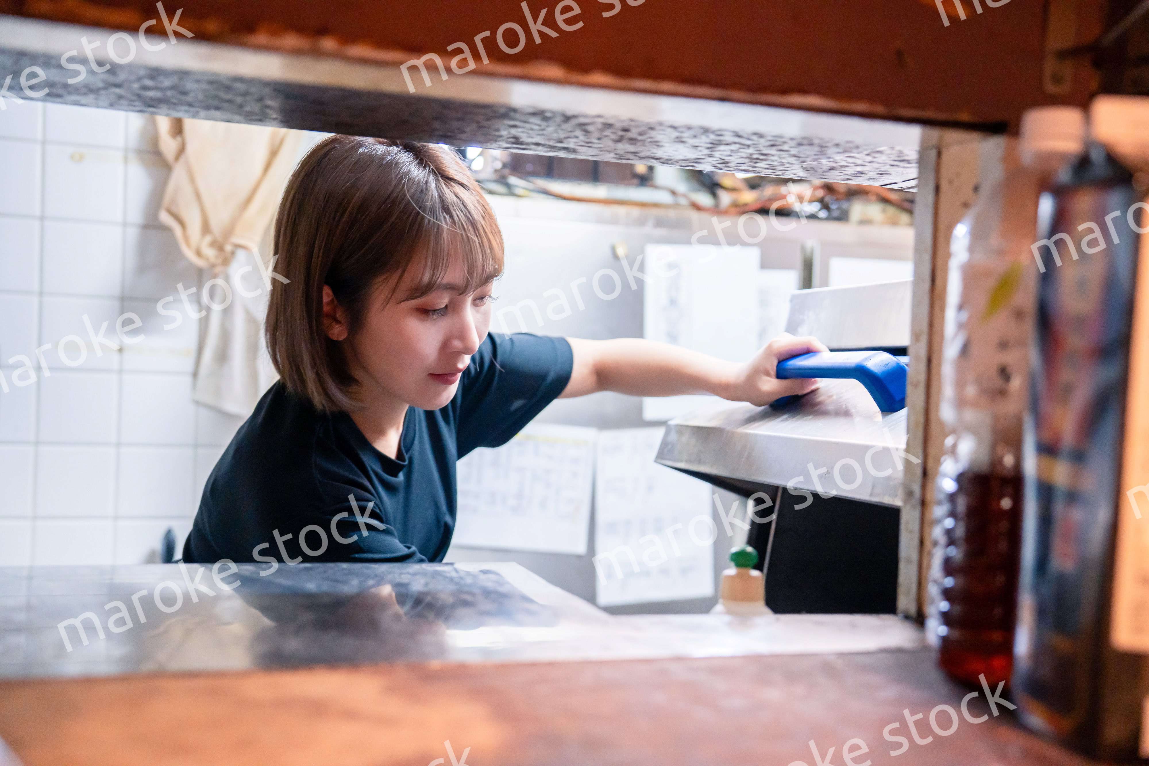 業務用の食洗機でお皿洗いをする飲食店スタッフ