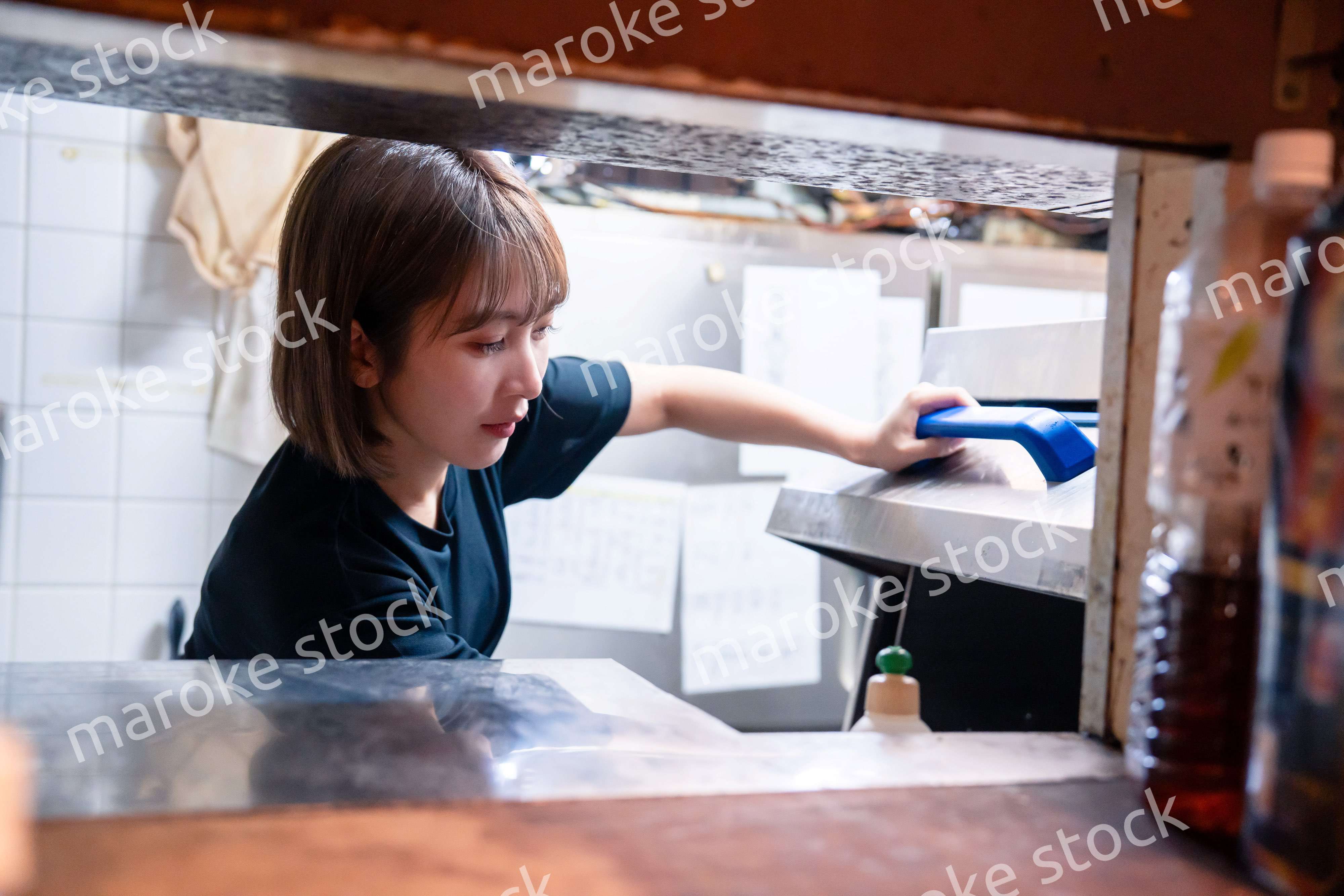 業務用の食洗機でお皿洗いをする飲食店スタッフ