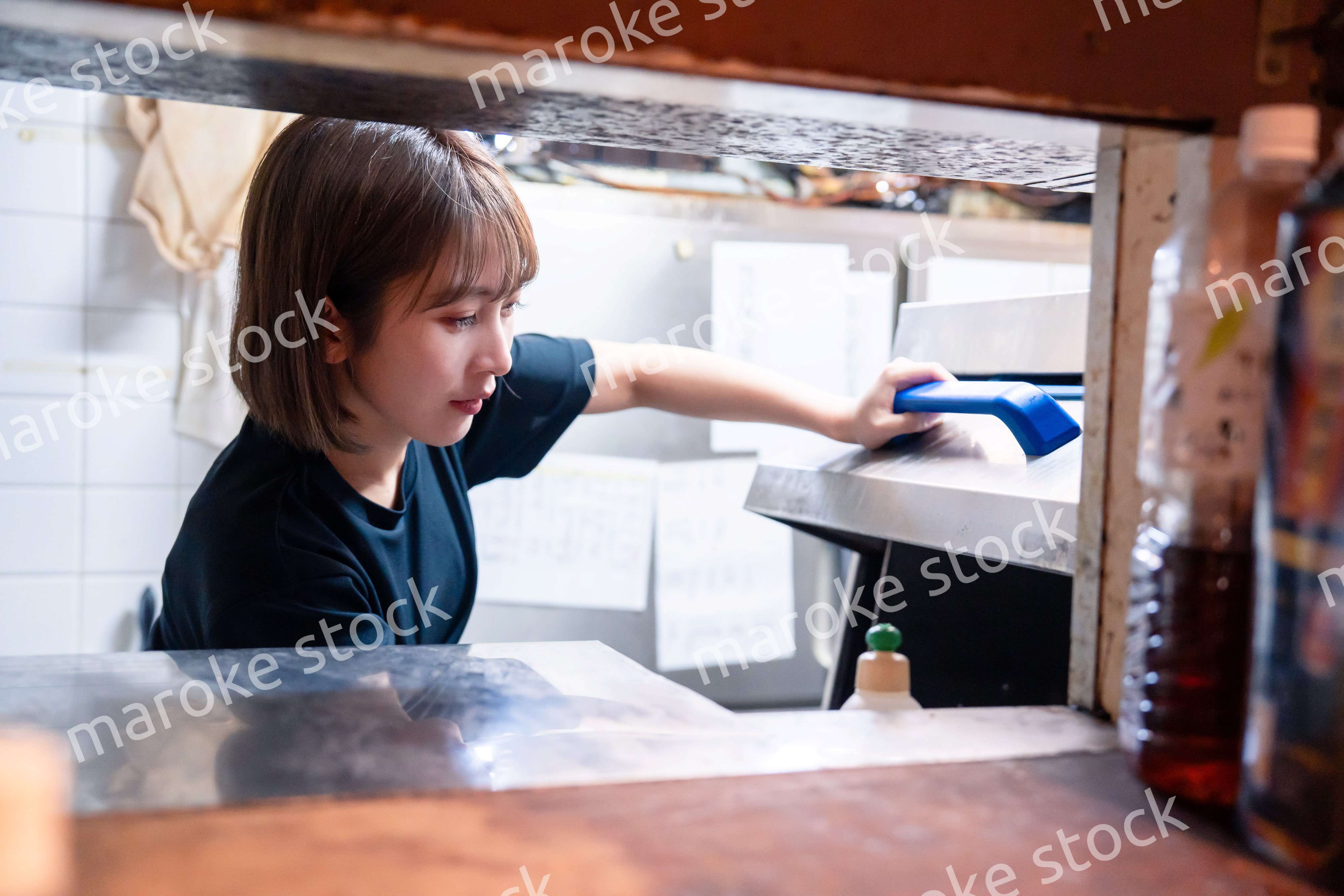 業務用の食洗機でお皿洗いをする飲食店スタッフ