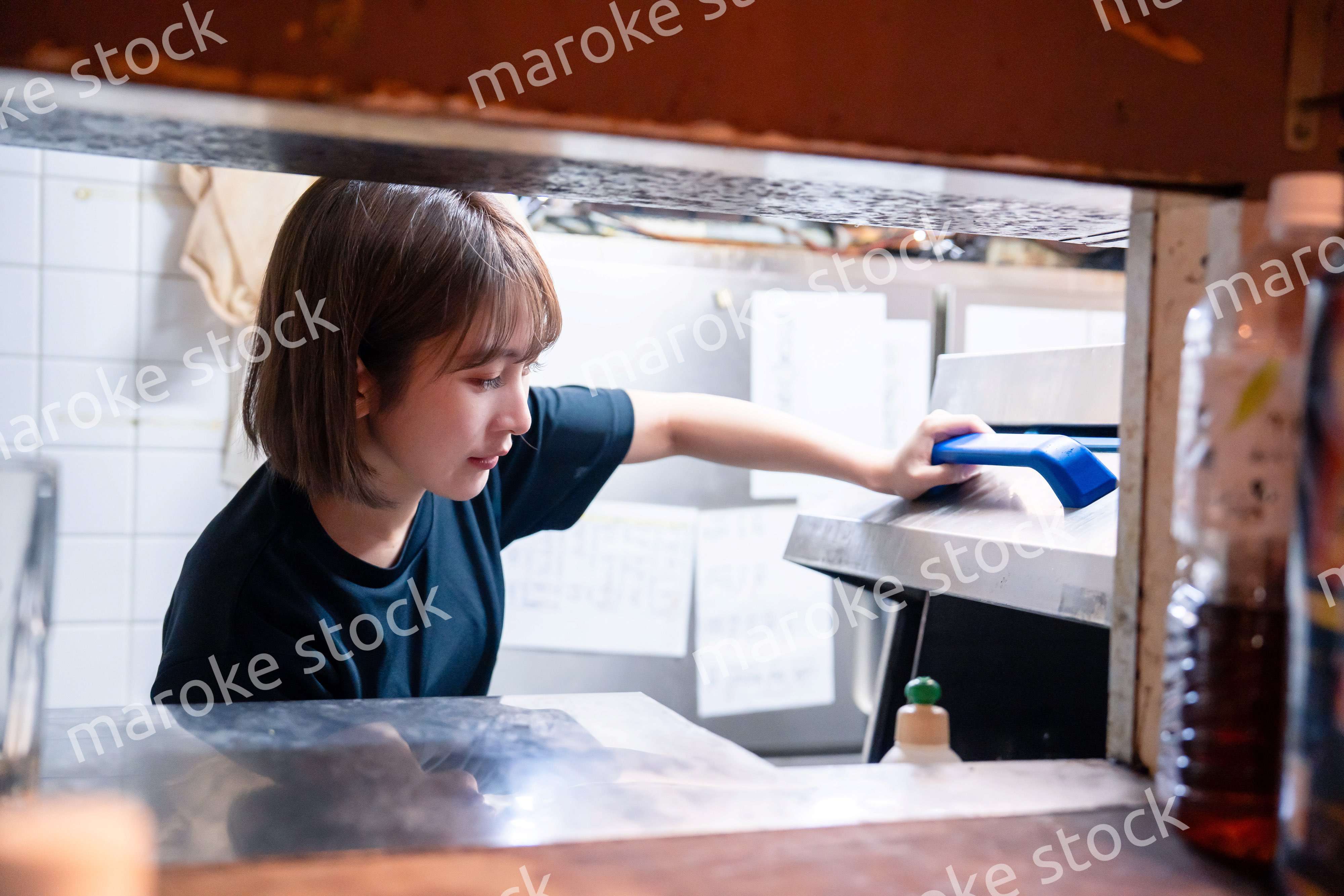 業務用の食洗機でお皿洗いをする飲食店スタッフ