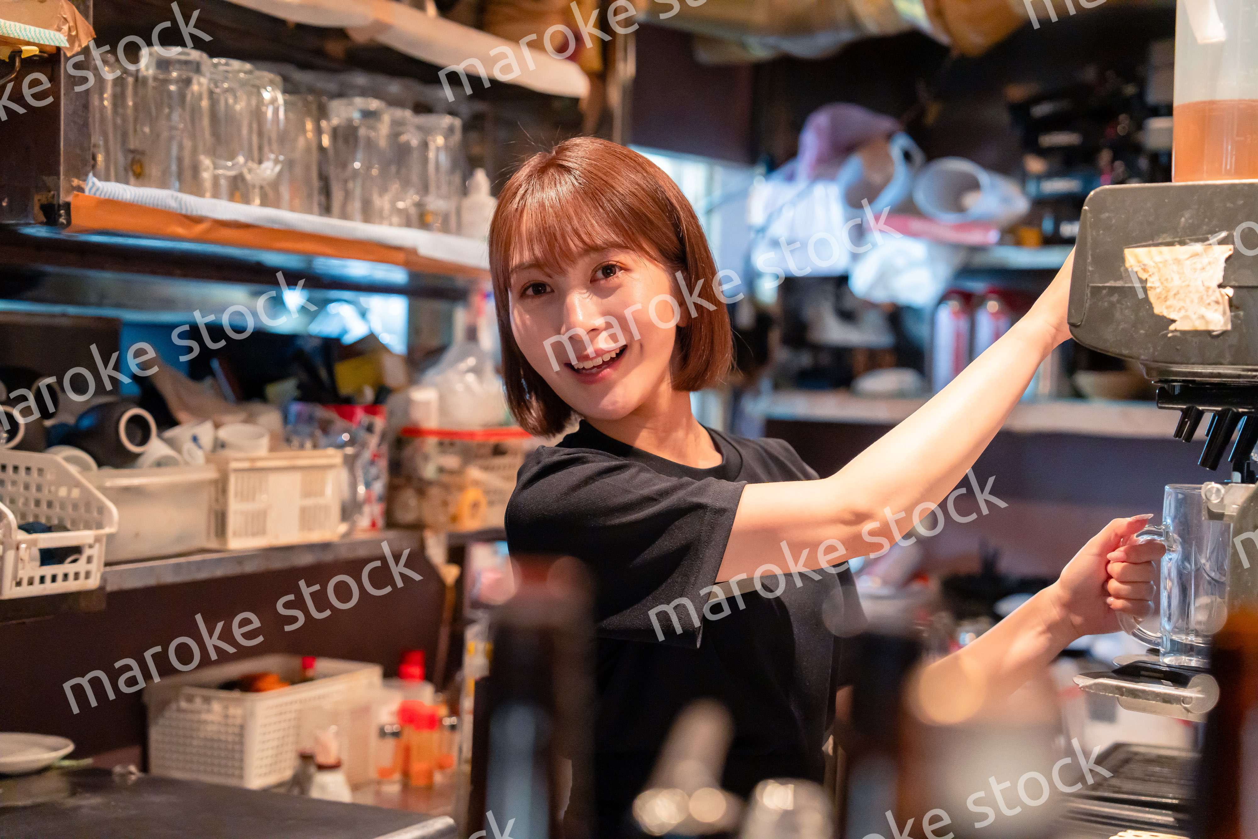 飲食店でビールサーバーを使う女性の店員