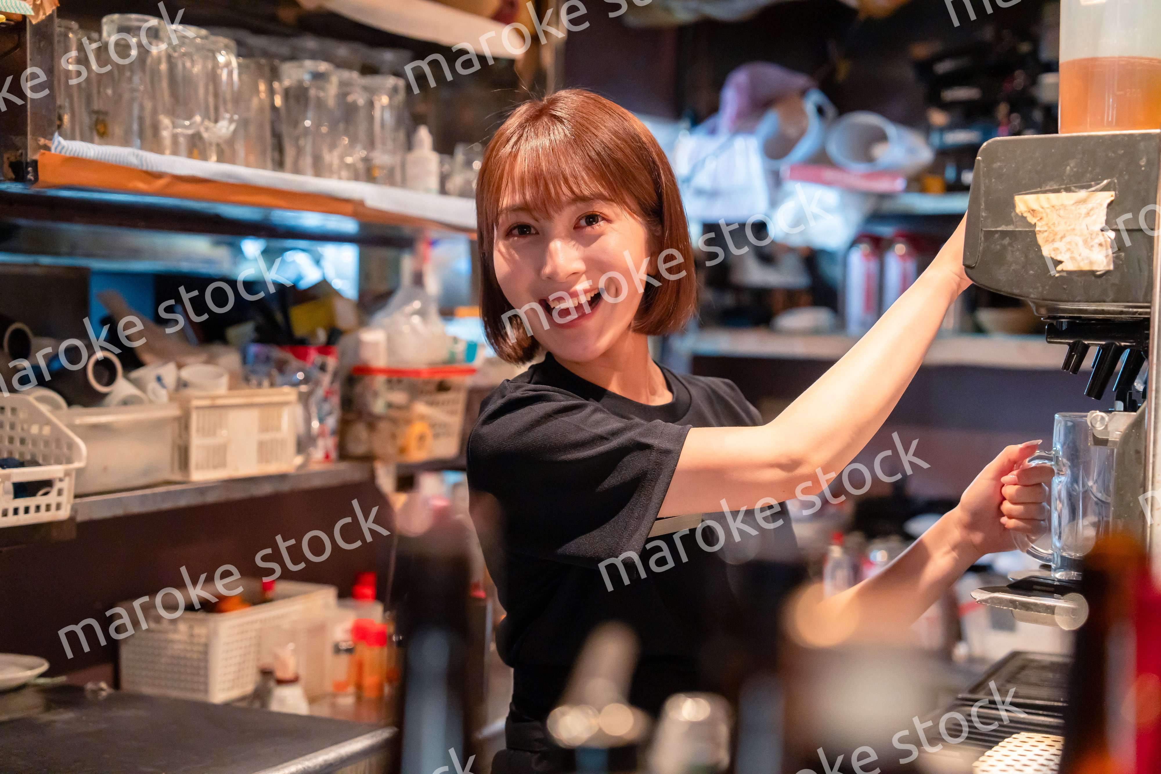 飲食店でビールサーバーを使う女性の店員