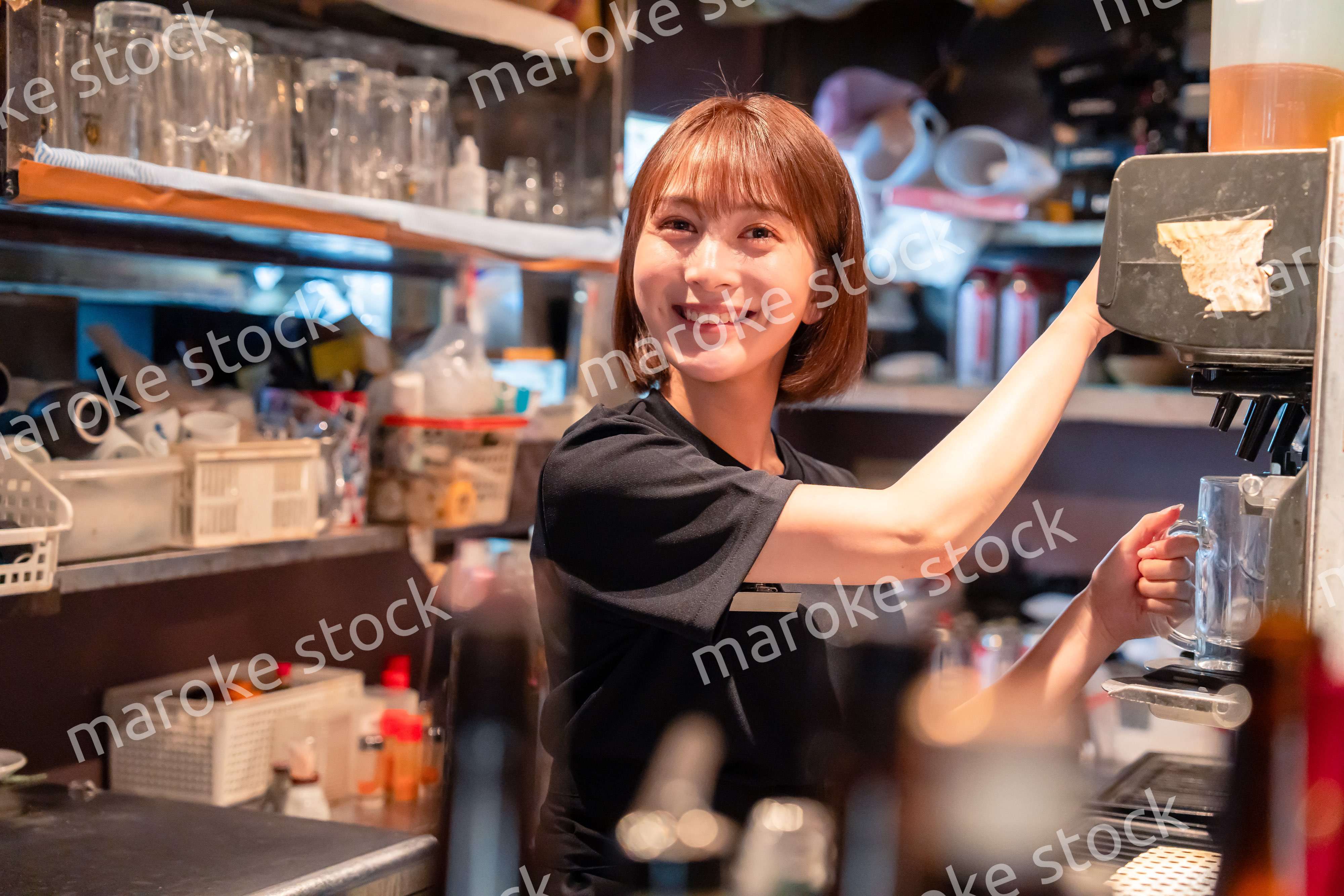 飲食店でビールサーバーを使う女性の店員