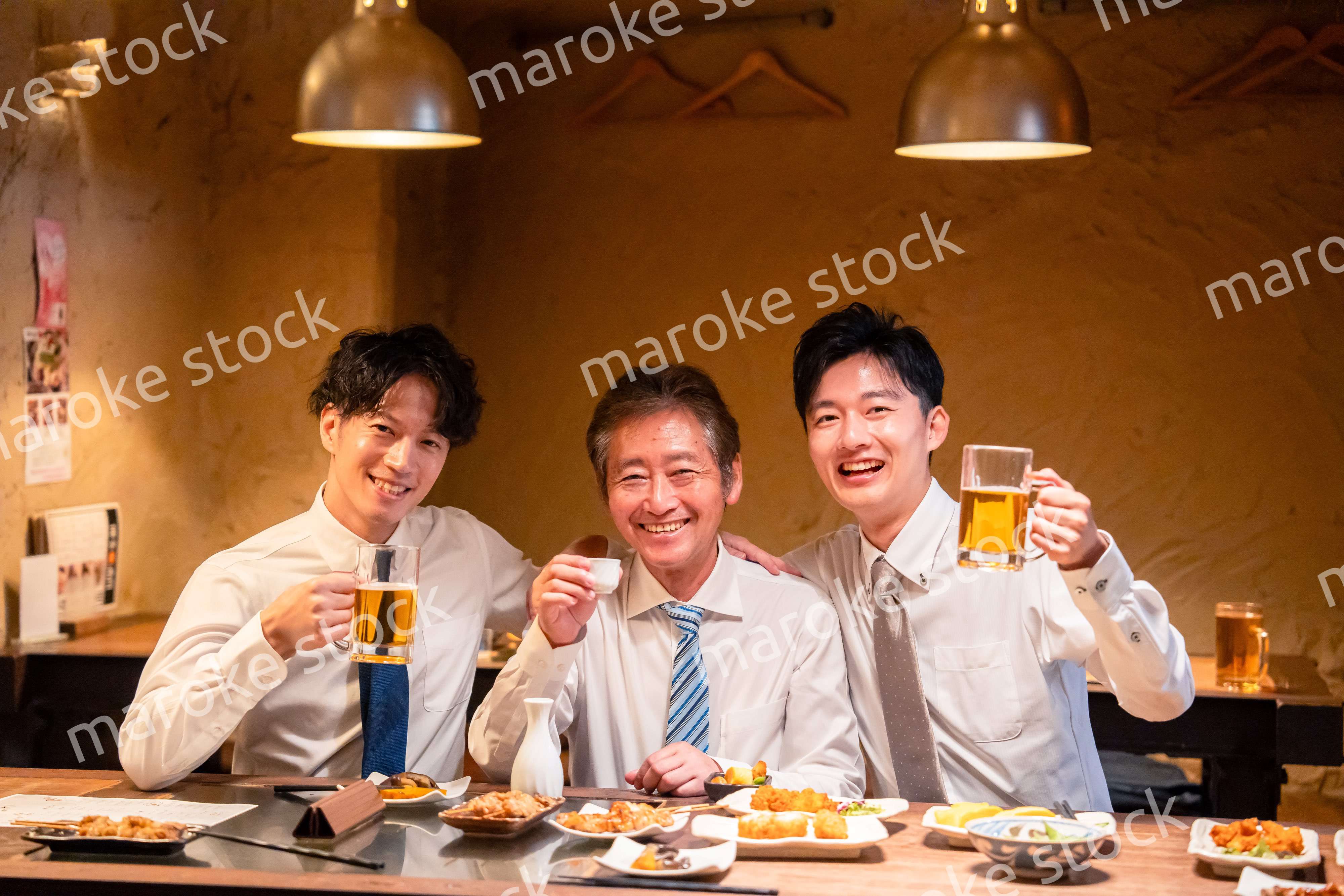 上司と肩を組みながら居酒屋で飲むサラリーマン