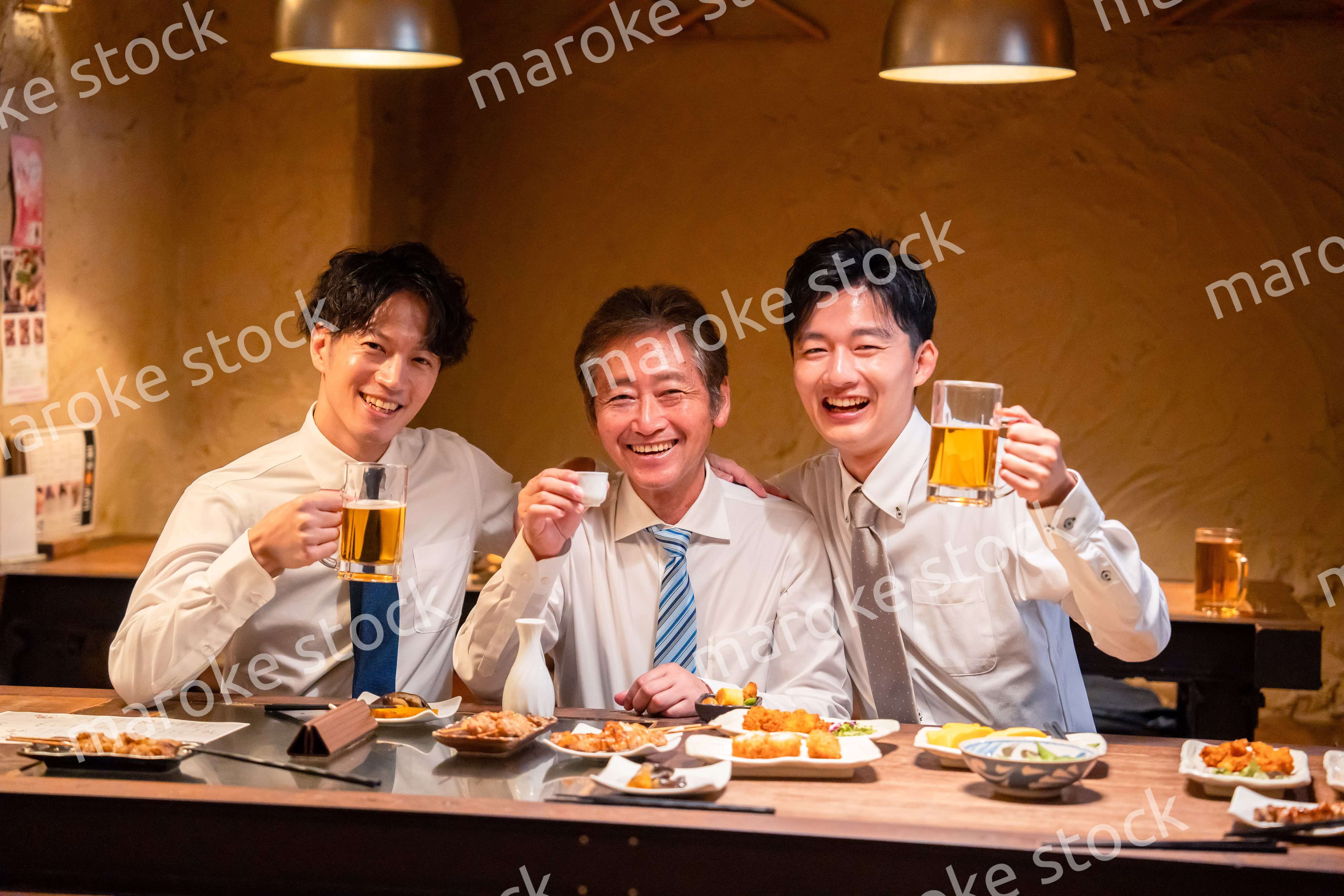 上司と肩を組みながら居酒屋で飲むサラリーマン