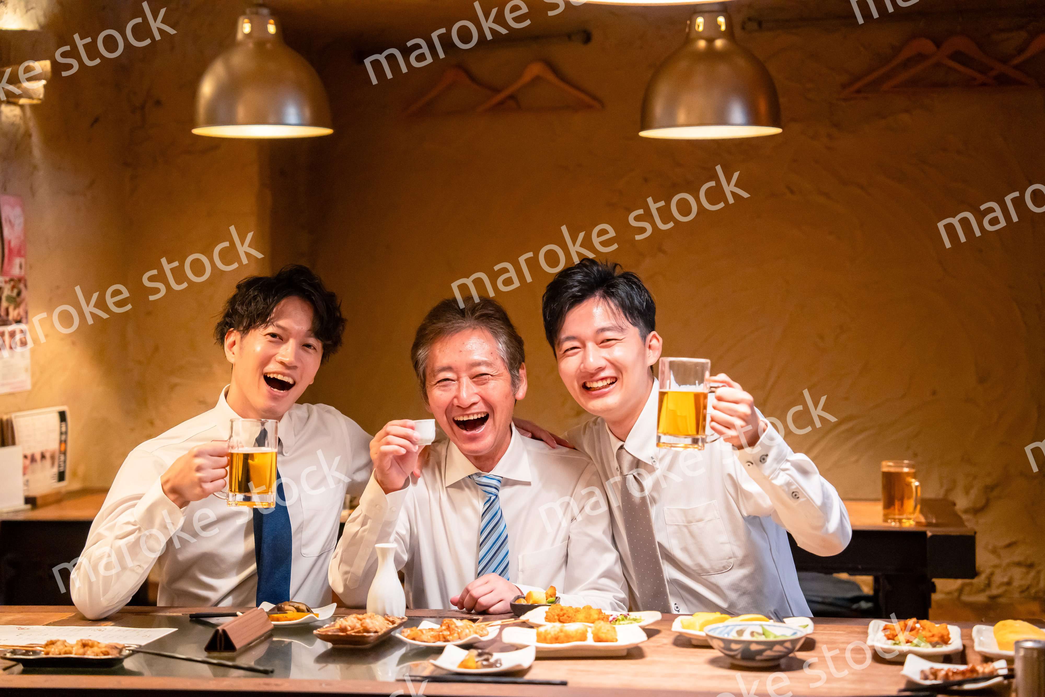 上司と肩を組みながら居酒屋で飲むサラリーマン