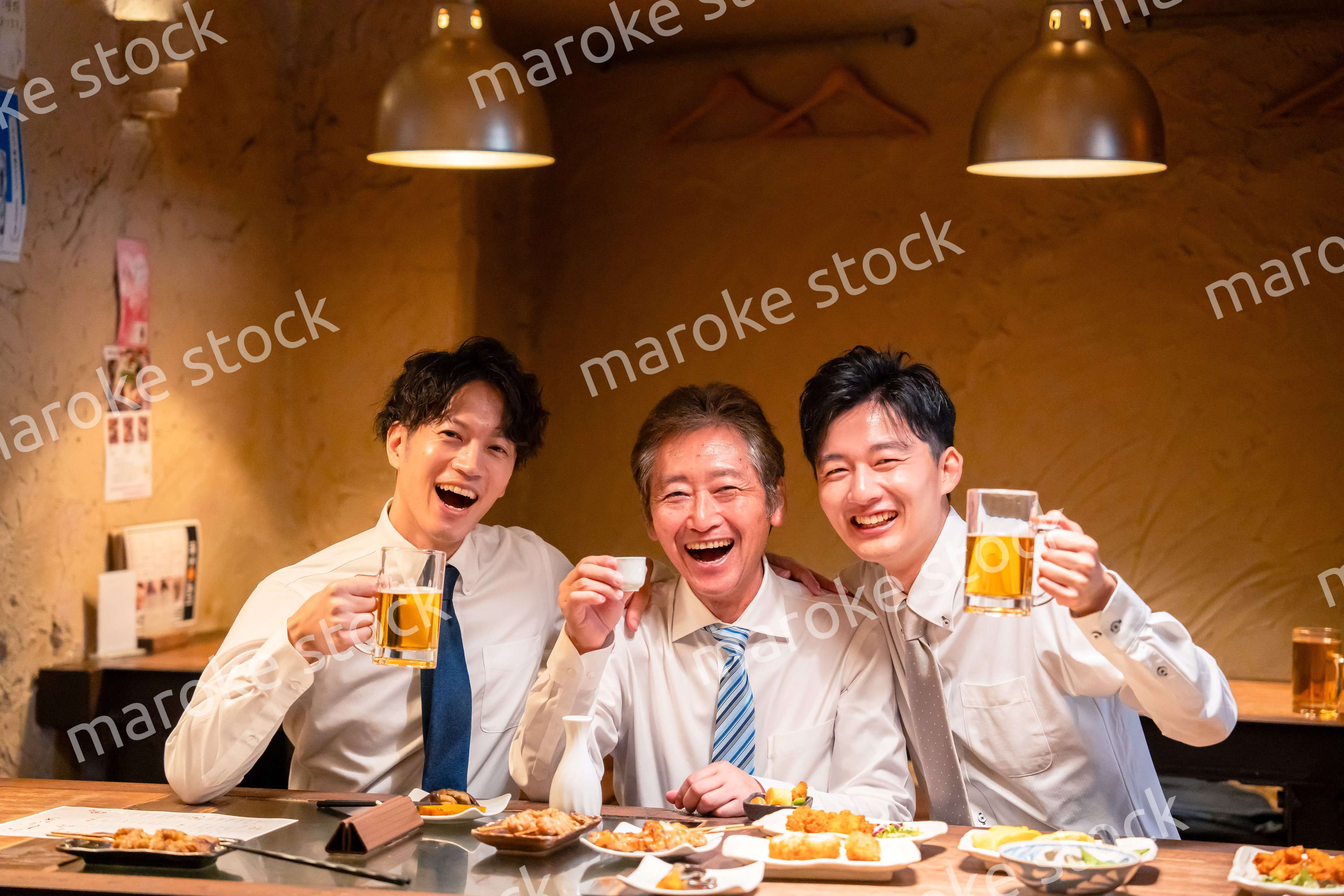 上司と肩を組みながら居酒屋で飲むサラリーマン