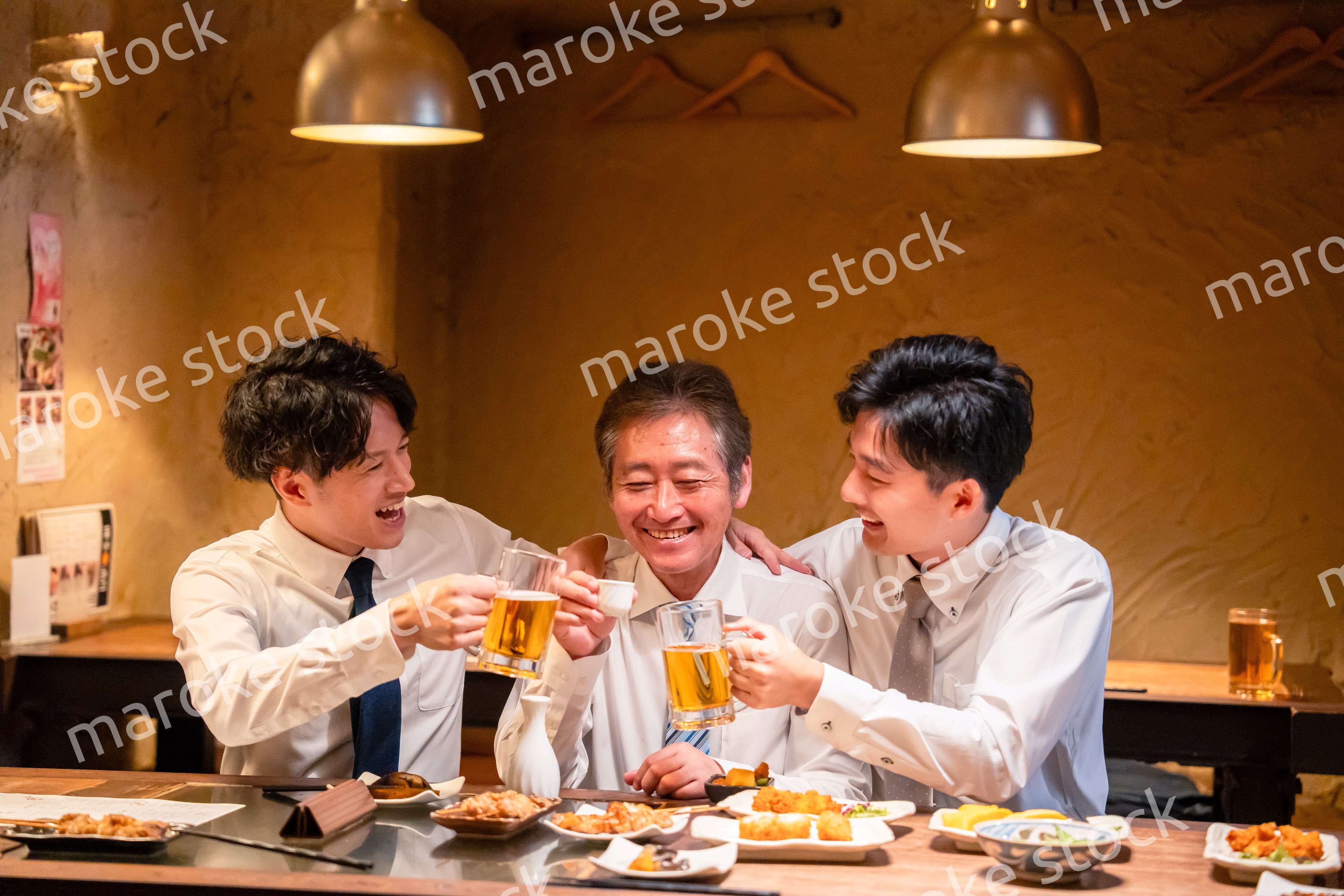 上司と肩を組みながら居酒屋で飲むサラリーマン