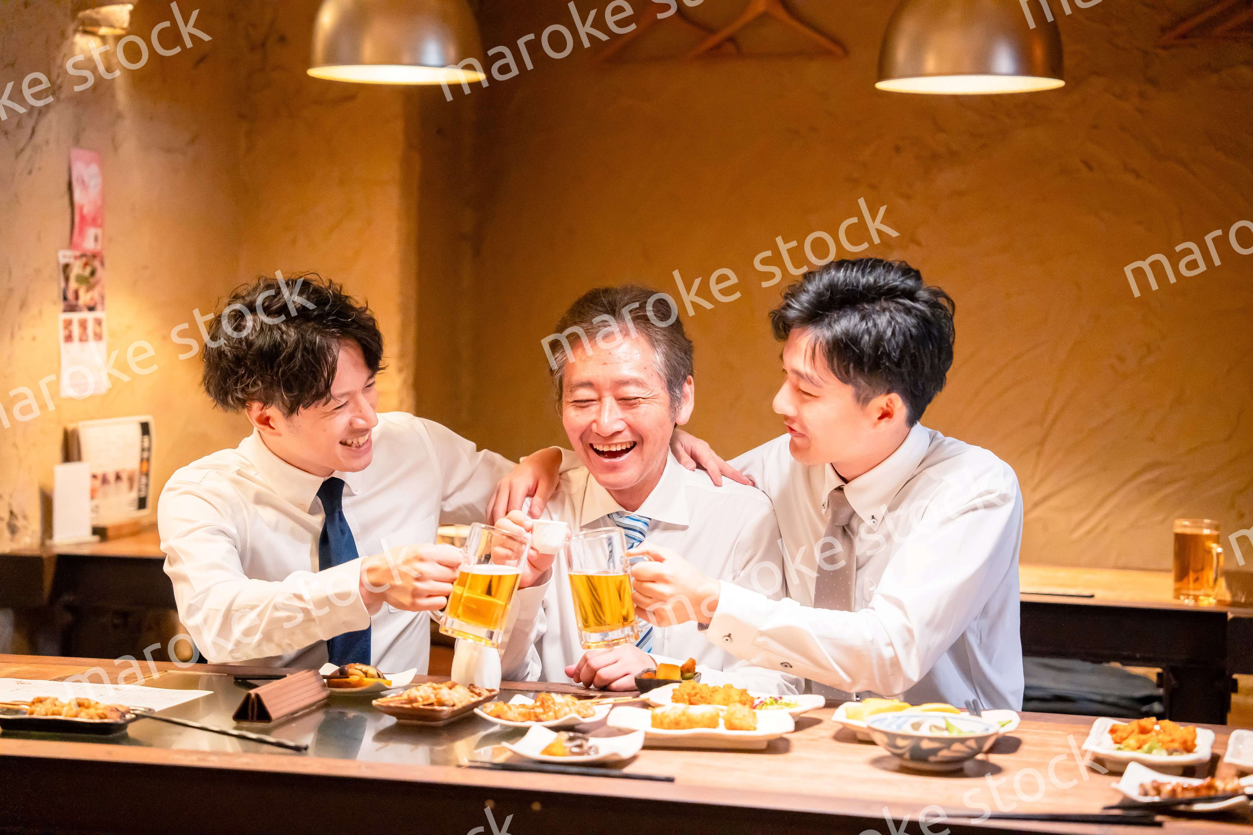 上司と肩を組みながら居酒屋で飲むサラリーマン