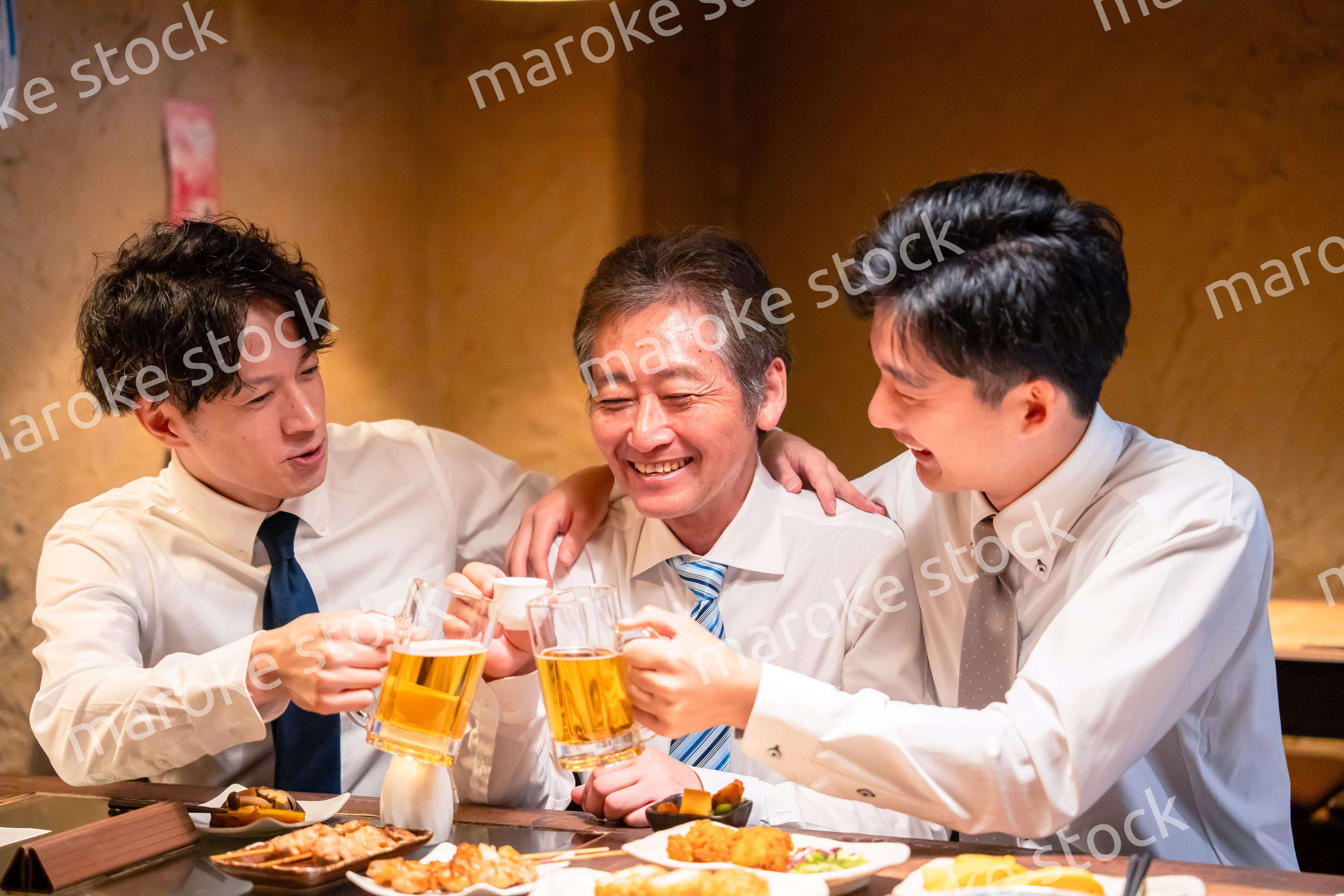 上司と肩を組みながら居酒屋で飲むサラリーマン