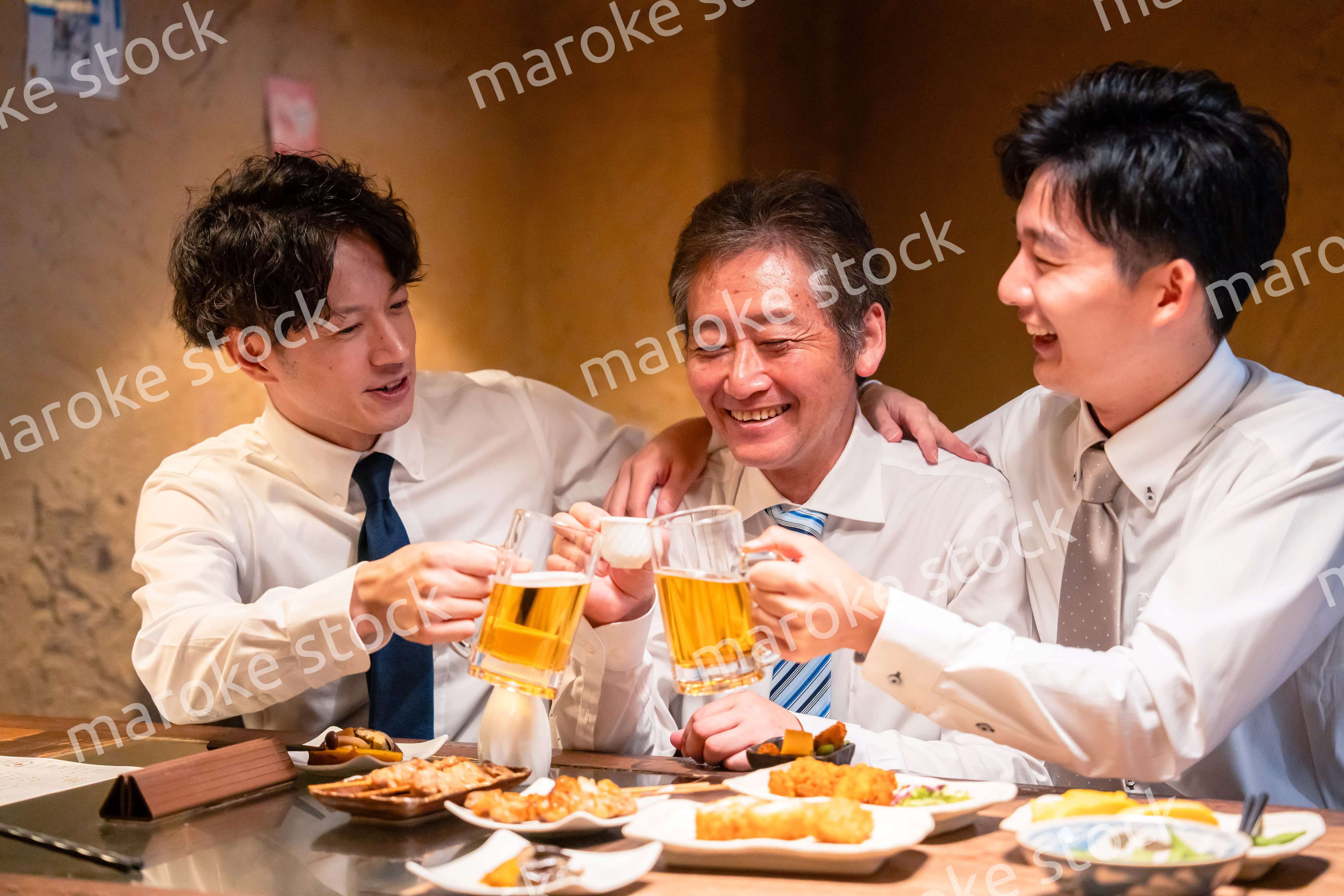 上司と肩を組みながら居酒屋で飲むサラリーマン