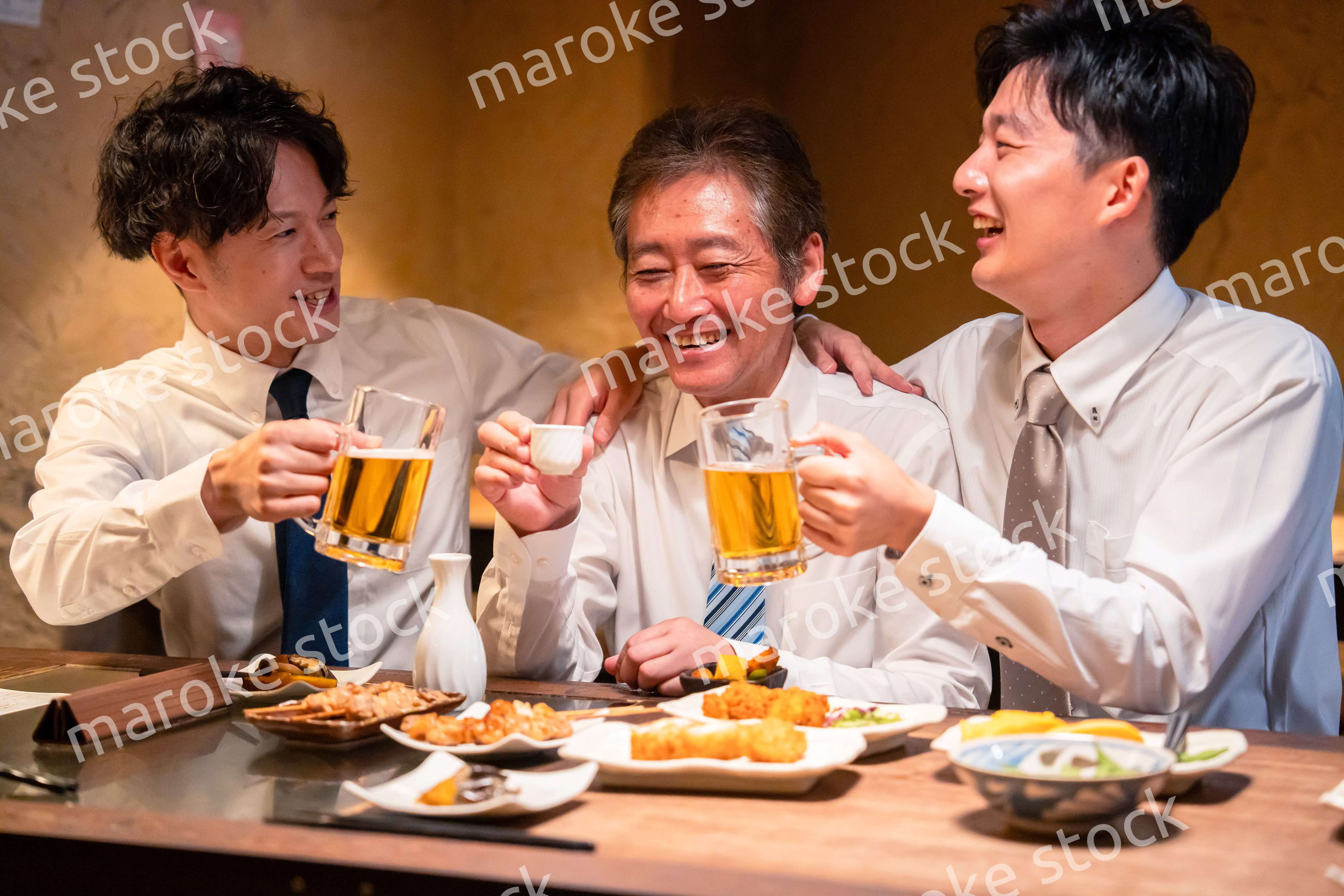 上司と肩を組みながら居酒屋で飲むサラリーマン